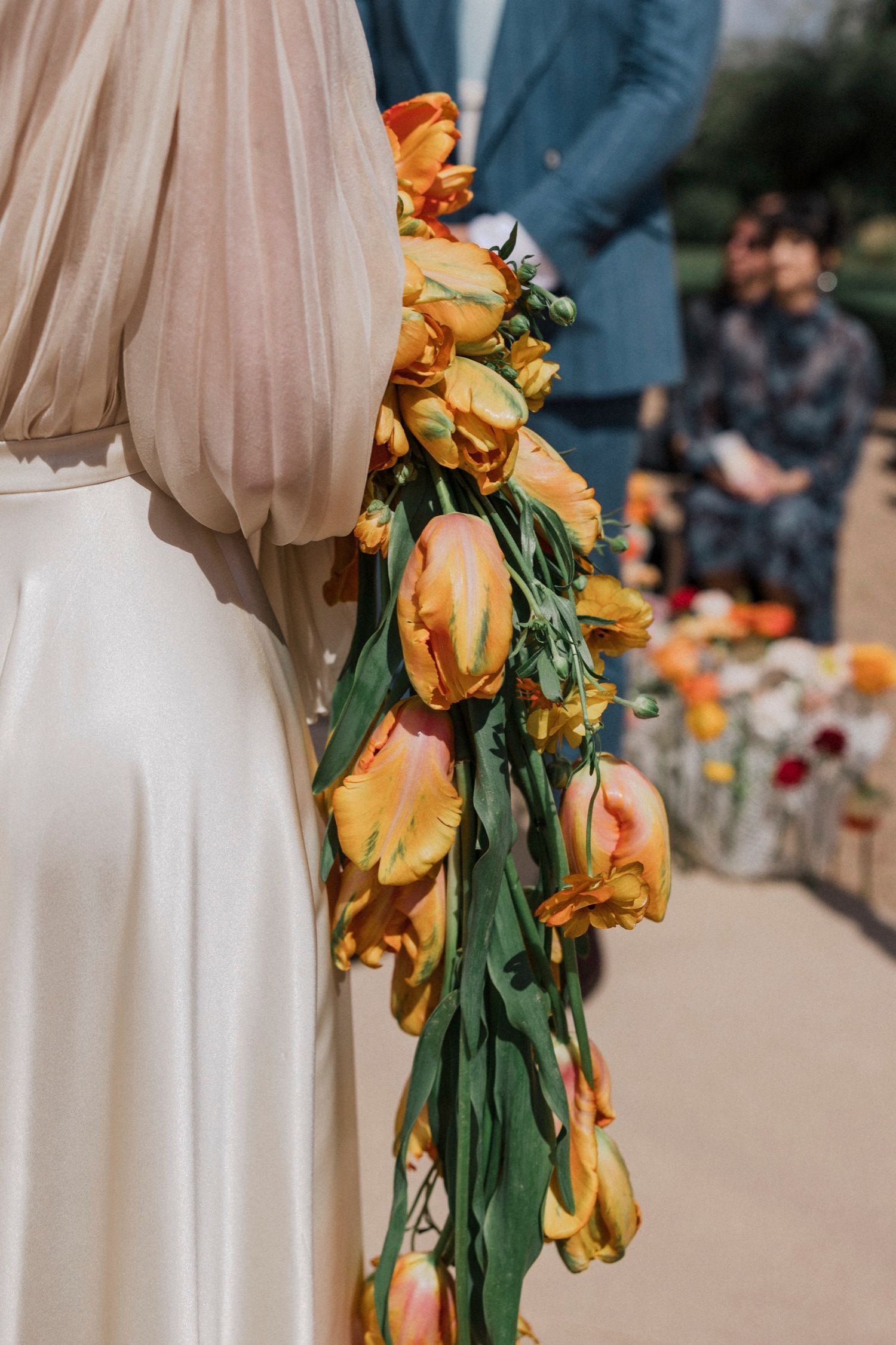 Dried yellow tulips with drooping petals hang decoratively against a light beige curtain backdrop.