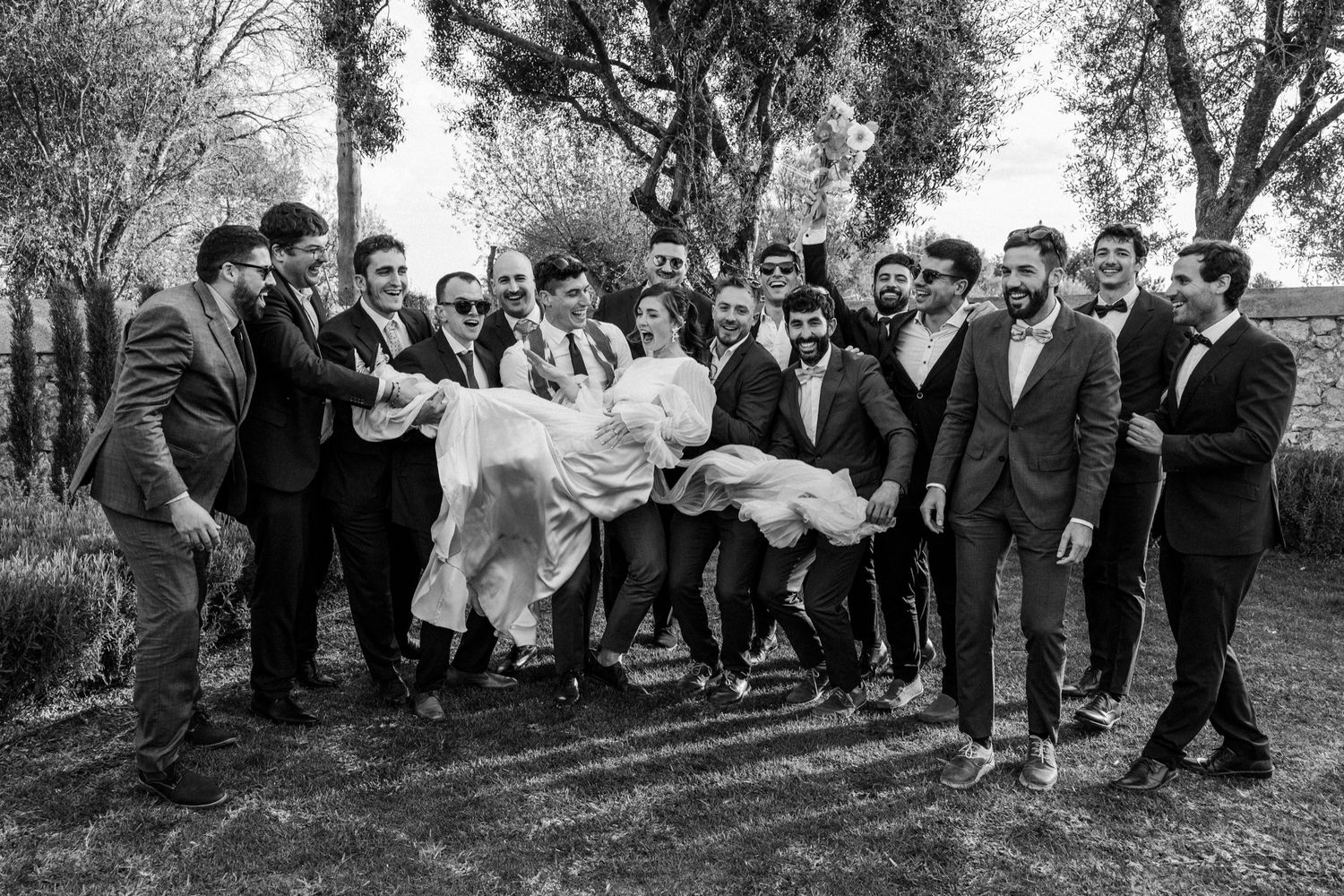 Black and white panoramic series of wedding guests gathered outdoors for group photos.