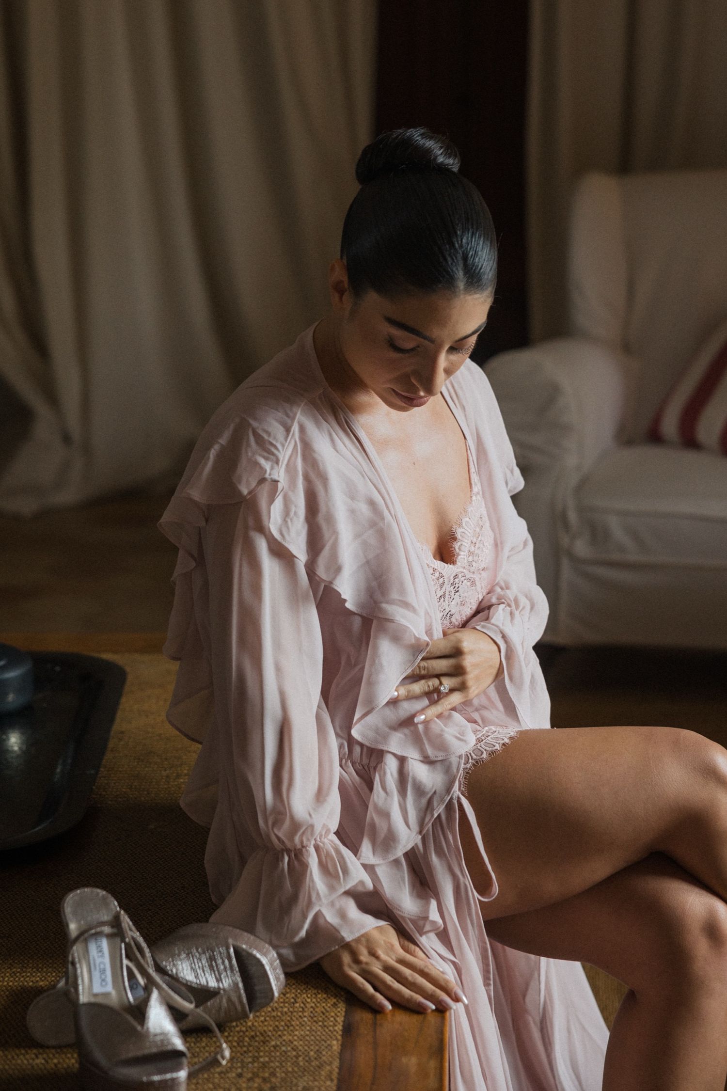 Pink ruffled dress detail in warm natural lighting against a rustic wooden surface.