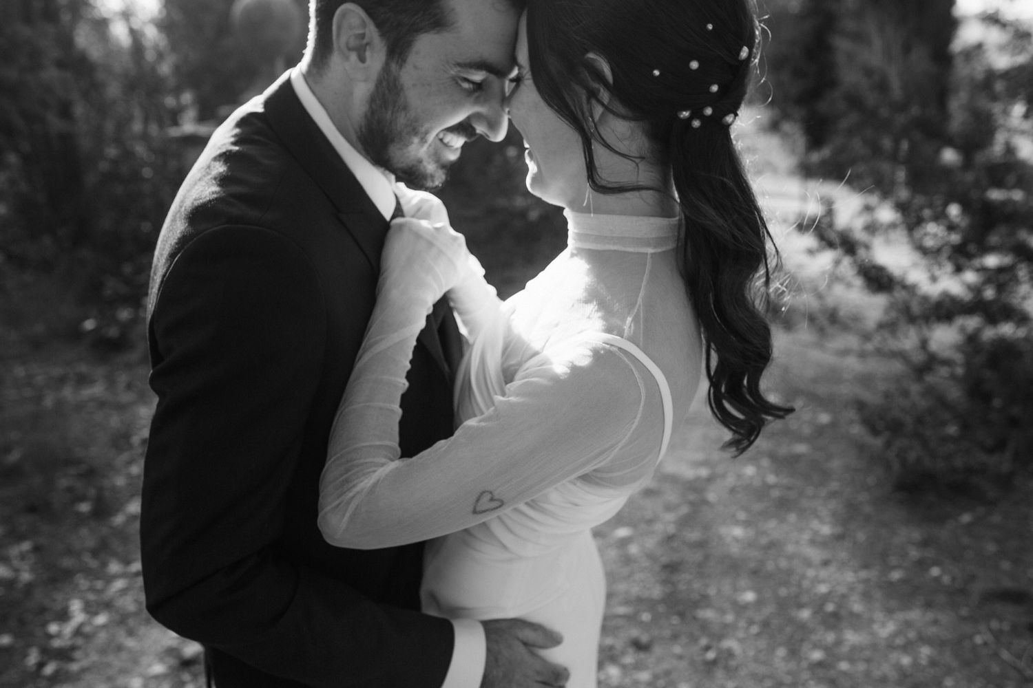 Romantic black and white wedding photo series showing intimate moments between newlyweds in an outdoor setting.