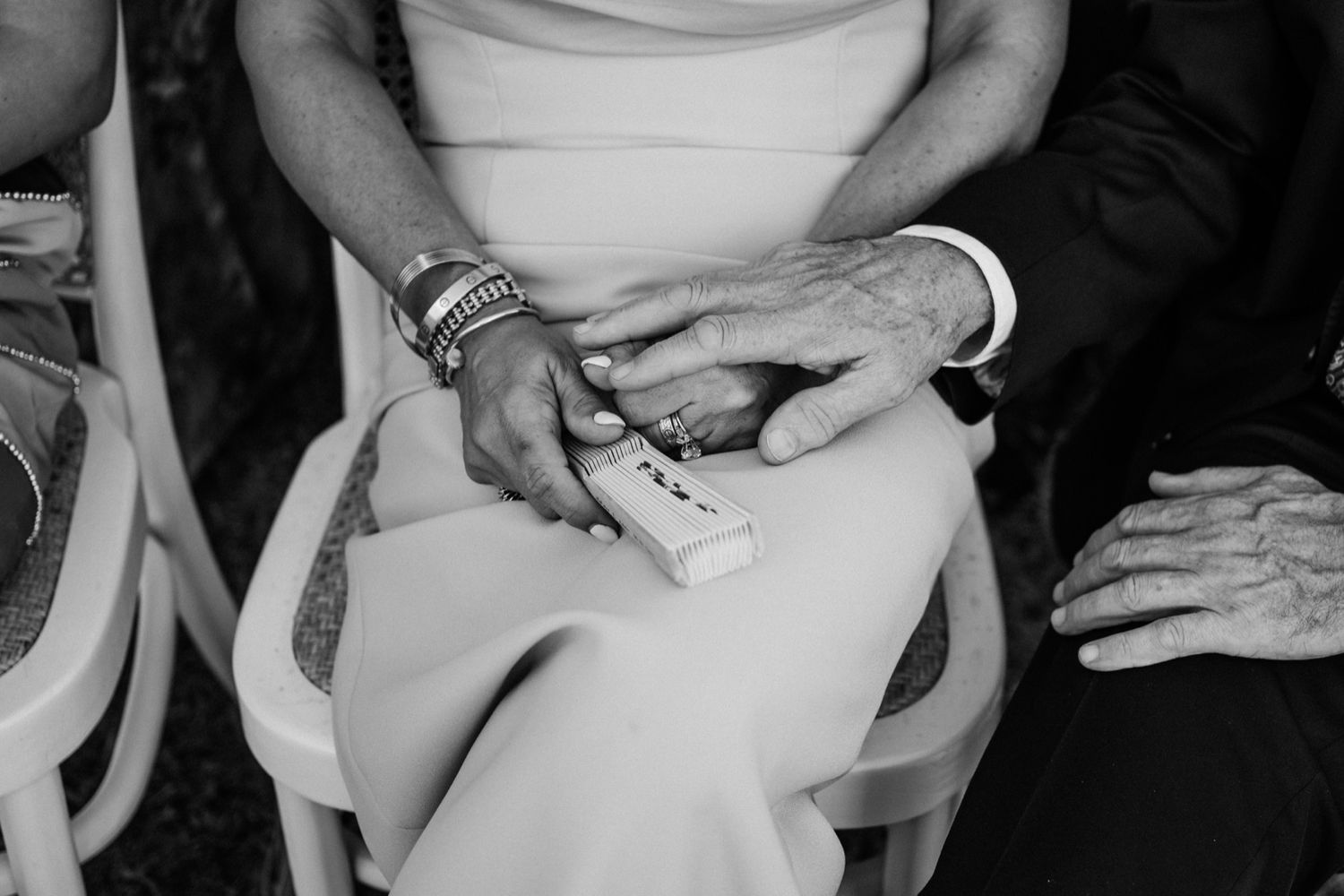 A black and white close-up photo of hands holding white ceramic coffee mugs.