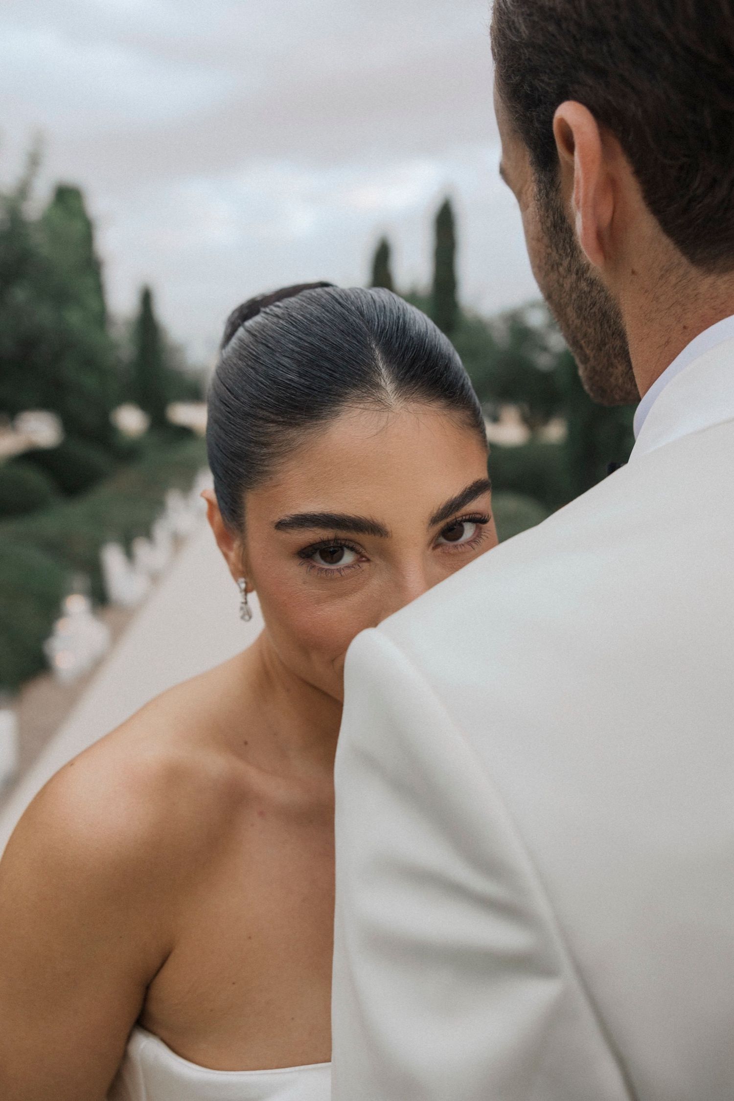 A series of artistic wedding photos showing close-up details of a couple in white attire against a blurred background.