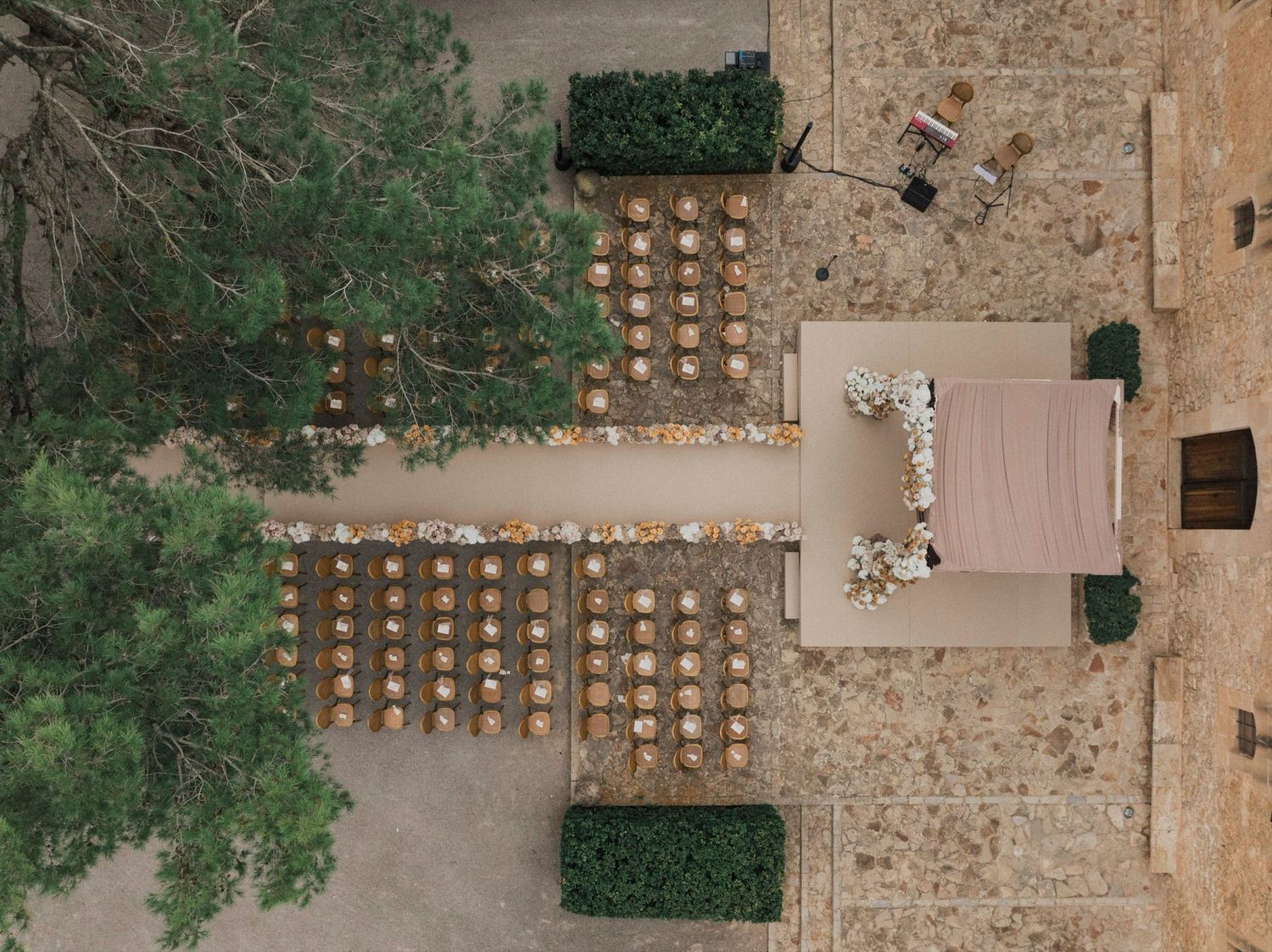 A rustic stone wall venue with wooden beams and string lights creates an elegant outdoor wedding reception setting.