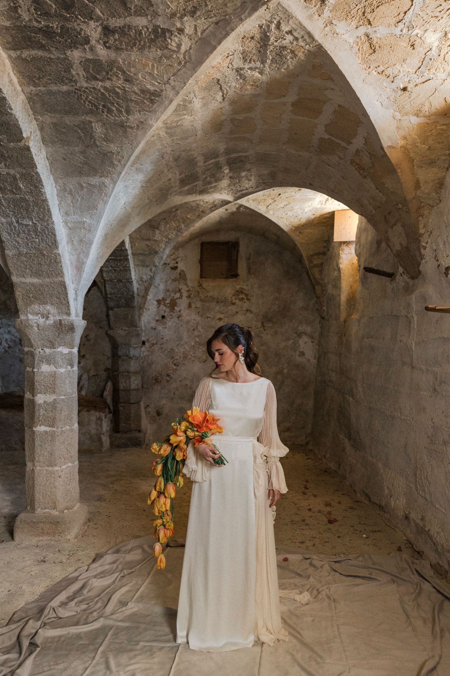 A series of photos showing a stone cellar or crypt with arched ceilings and someone in a flowing white dress.