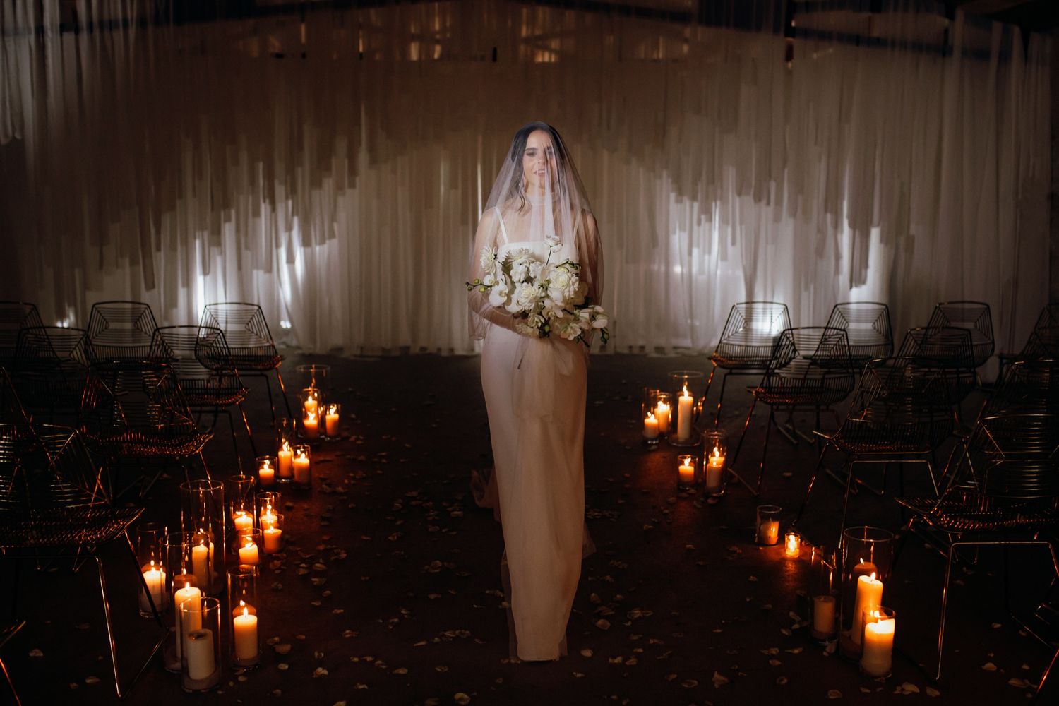 Candlelit pathway in a dark room with glowing lanterns creating a romantic and mysterious ambiance.