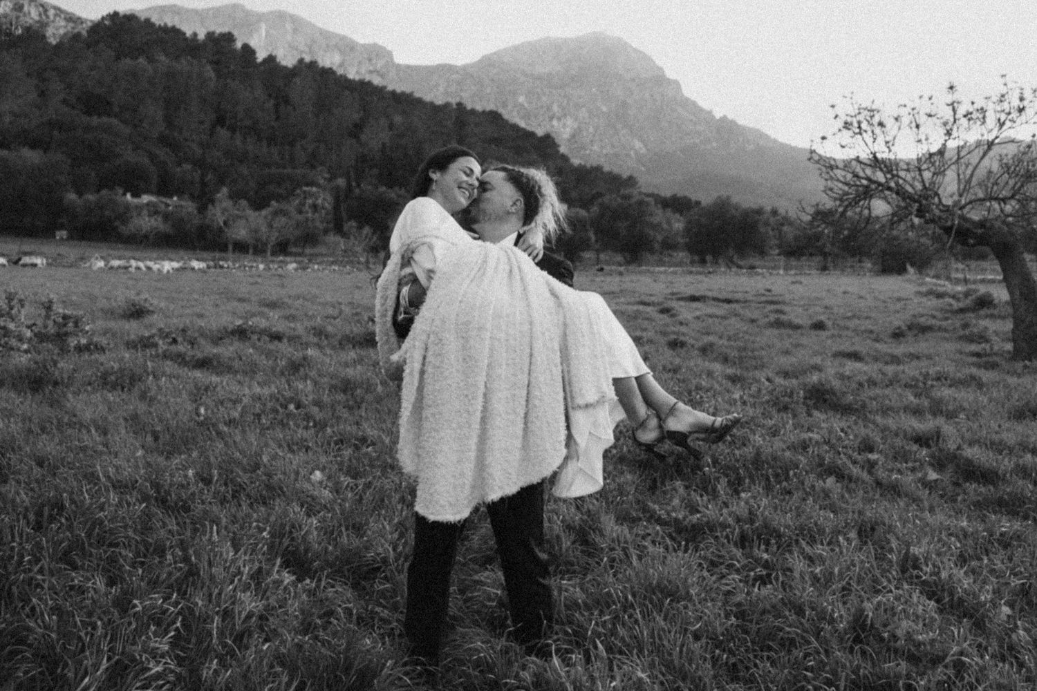 Couple embraces in a scenic mountain landscape during their wedding photoshoot.