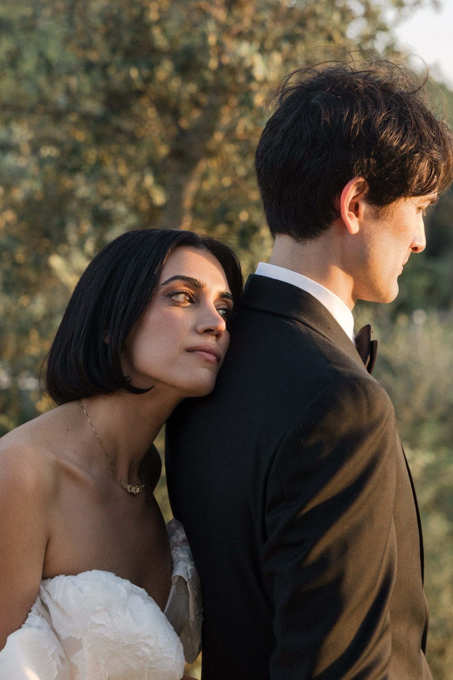 A romantic wedding portrait sequence showing tender moments between the couple against natural foliage.