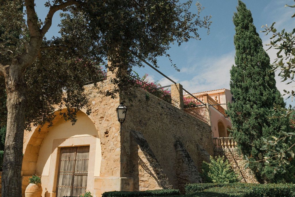 Mediterranean stone architecture with cypress trees against a blue sky.