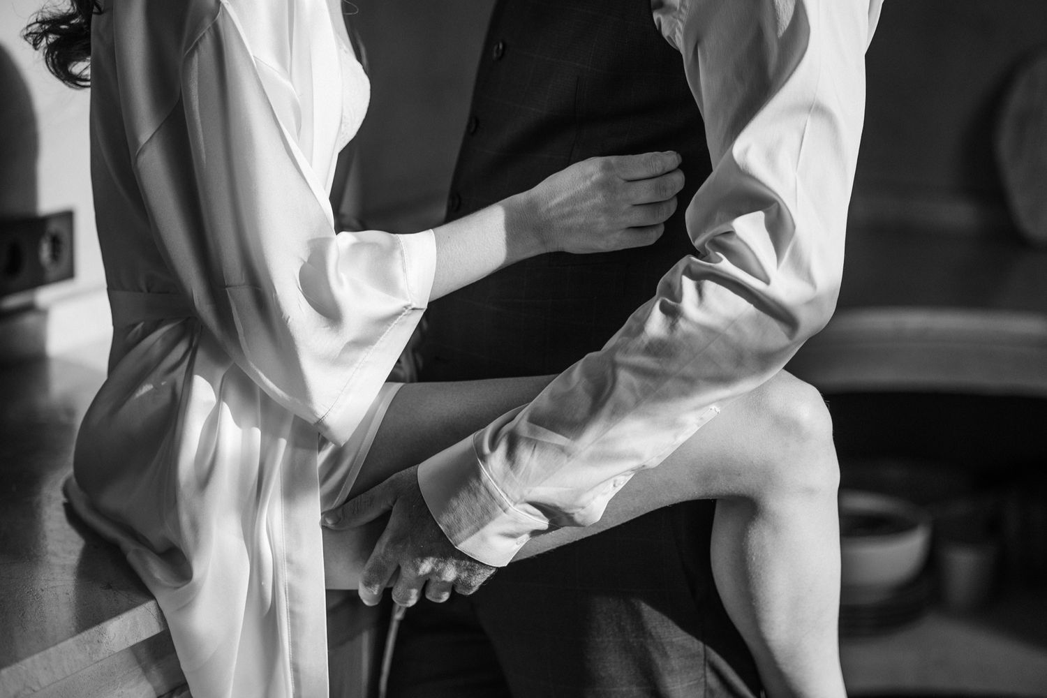 A black and white photo collage showing hands in white sleeves reaching and interacting with each other.