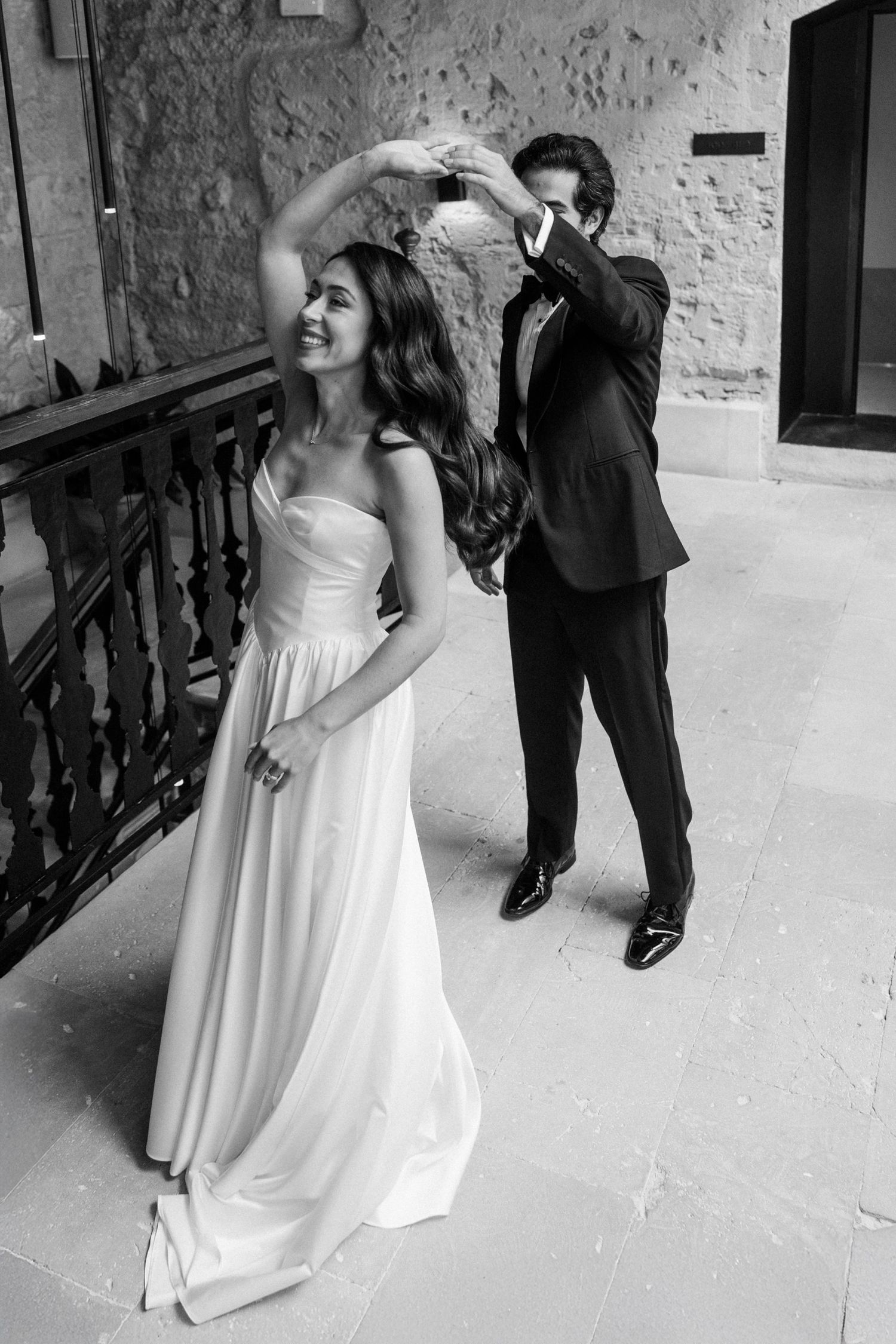 A sequence of black and white photos showing a bride in a flowing white dress dancing and twirling at a wedding reception.