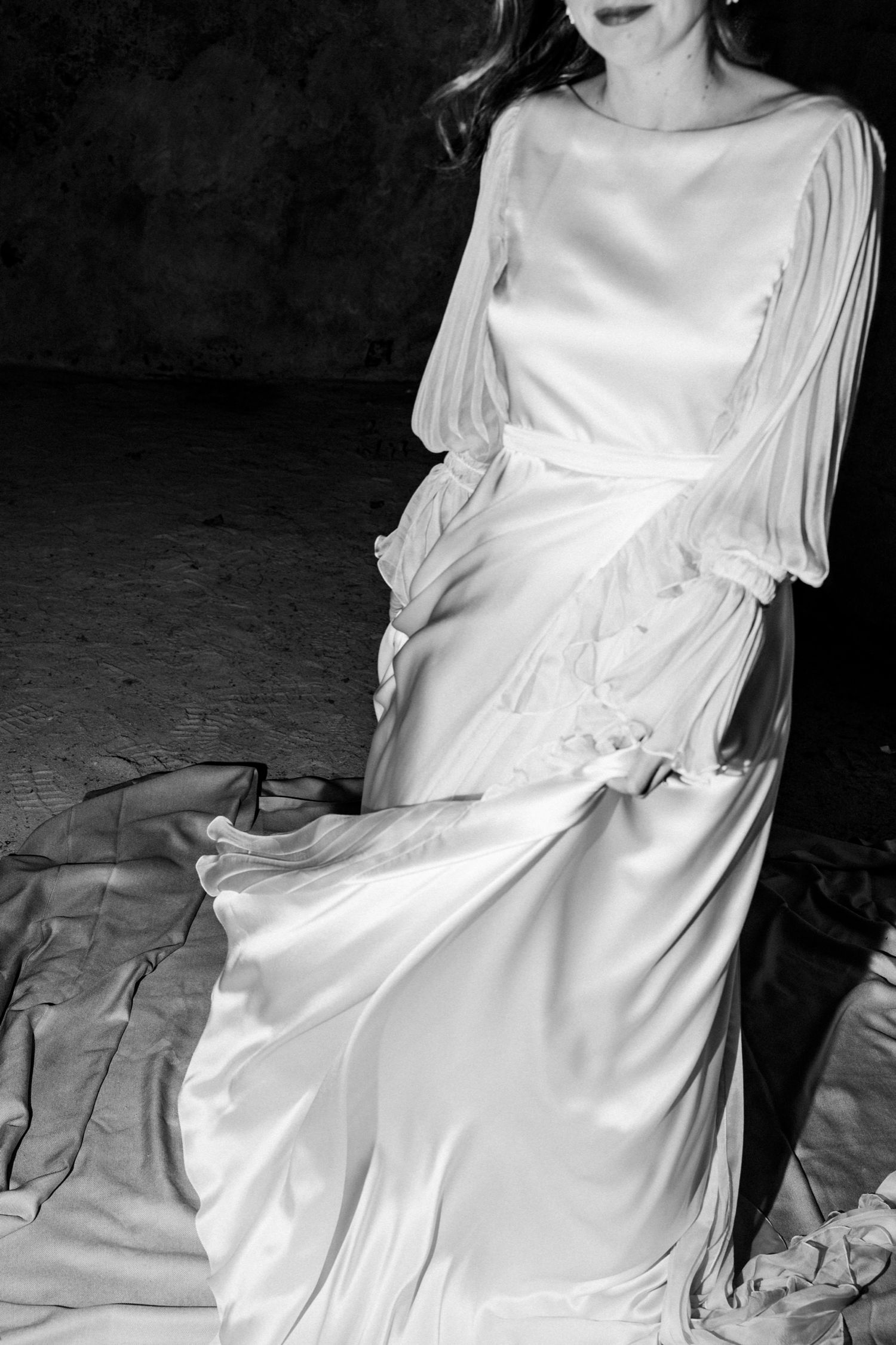 A series of black and white photographs showing a person in a flowing white dress against a dark background.