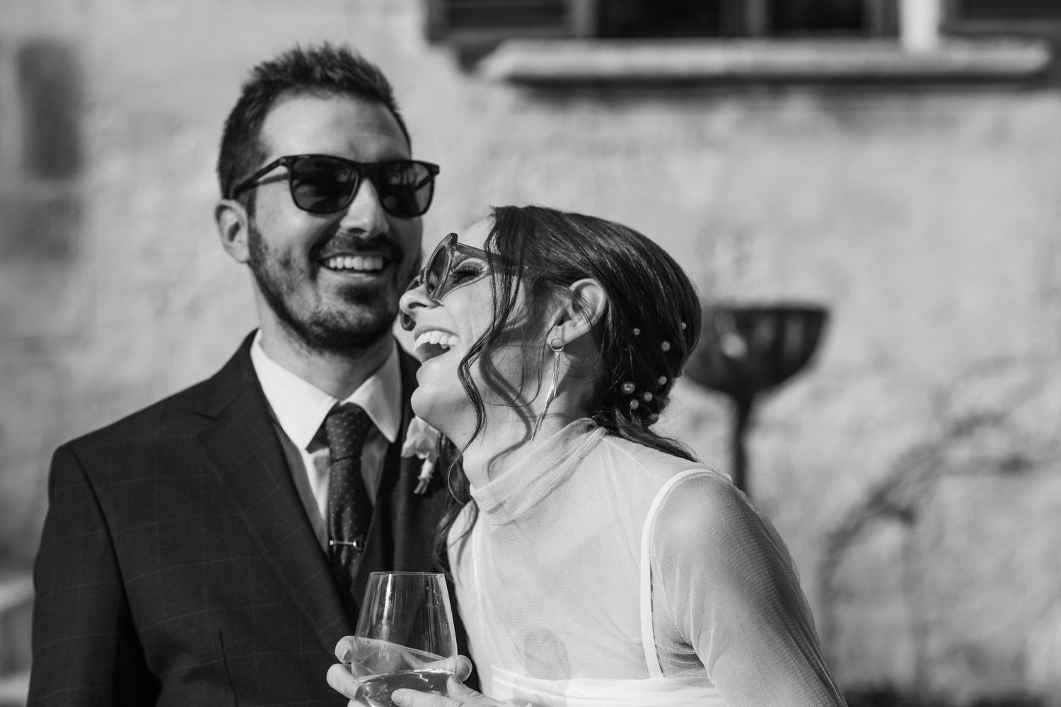 A couple in wedding attire embraces while sharing a romantic moment together in an outdoor setting.