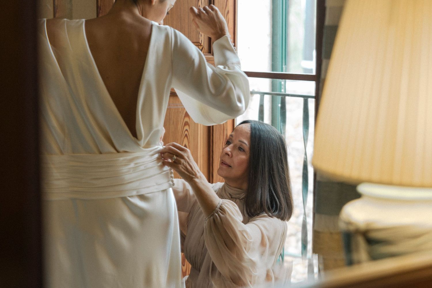 Soft window light falls on flowing white fabric as movement is captured in an indoor setting.