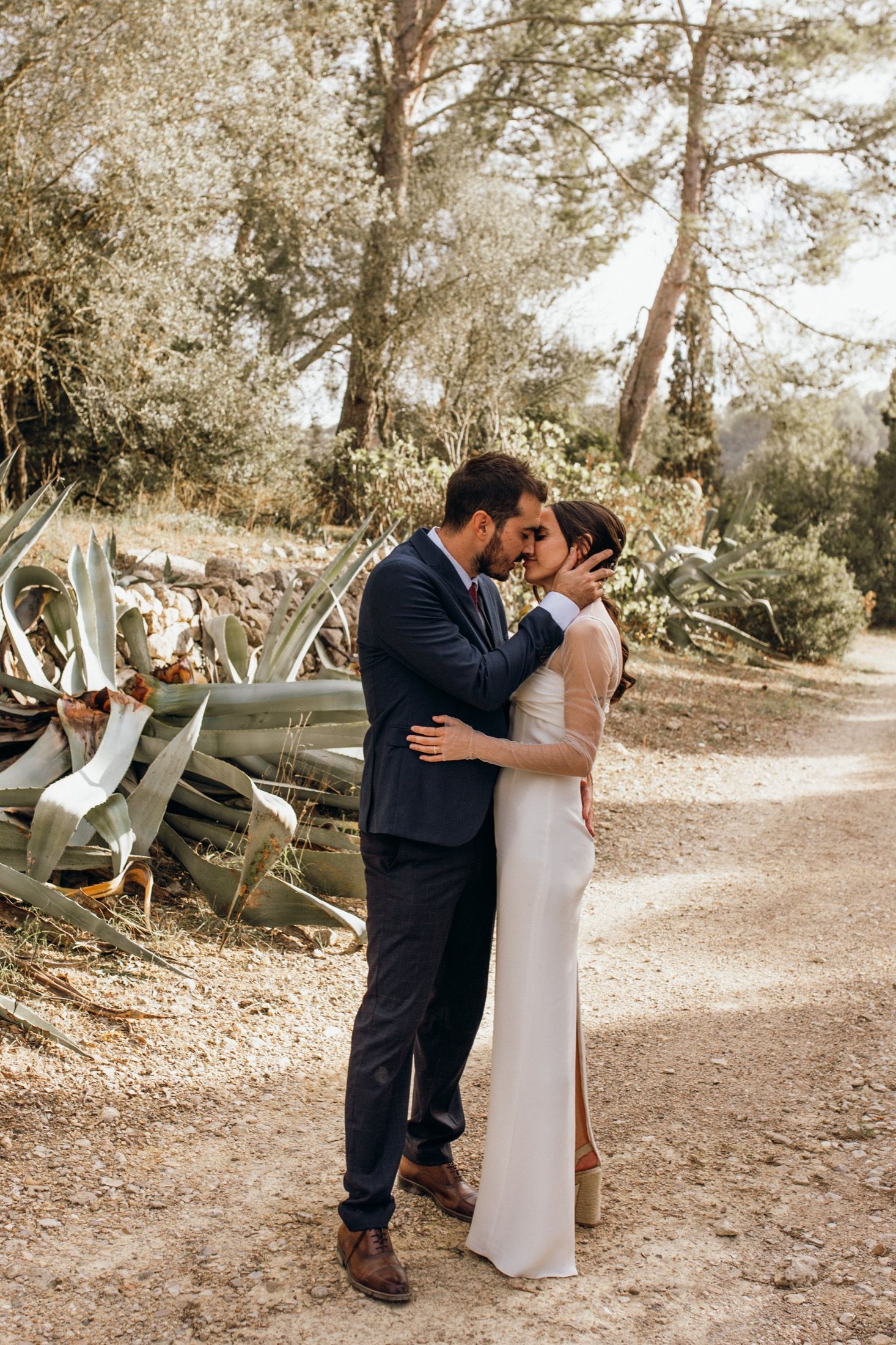 A romantic outdoor wedding moment captured in a series of sepia-toned photographs showing a couple embracing on a wooded path.