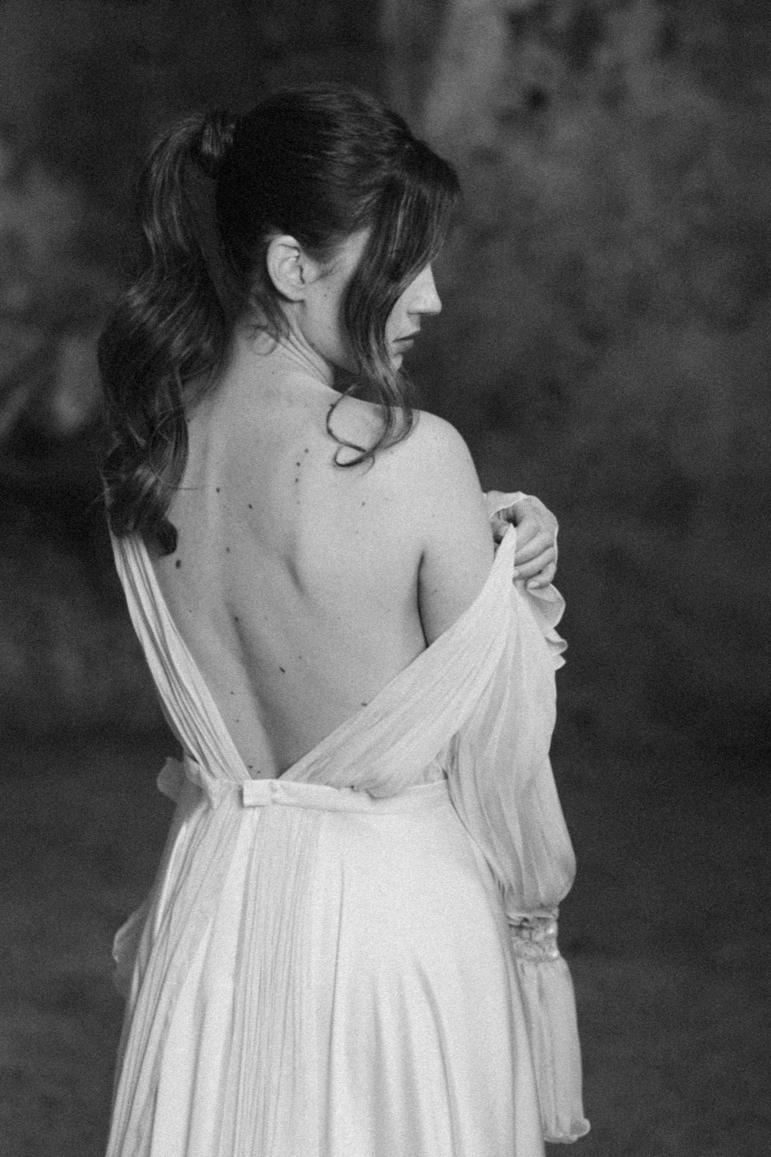 A series of black and white photos showing a person in a flowing white dress turning away from the camera.
