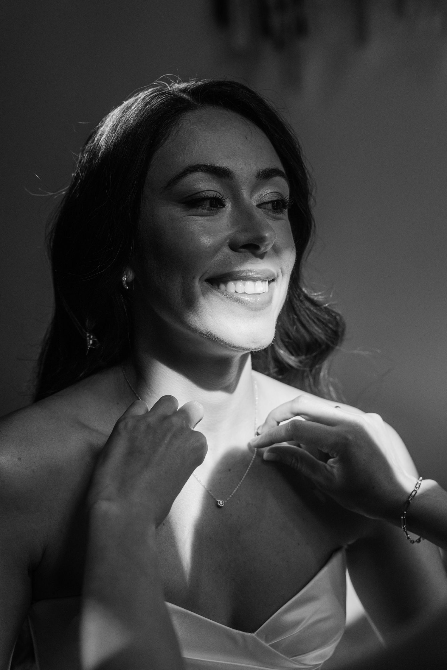 A black and white photo sequence showing a smiling expression emerging from shadows in dramatic lighting.