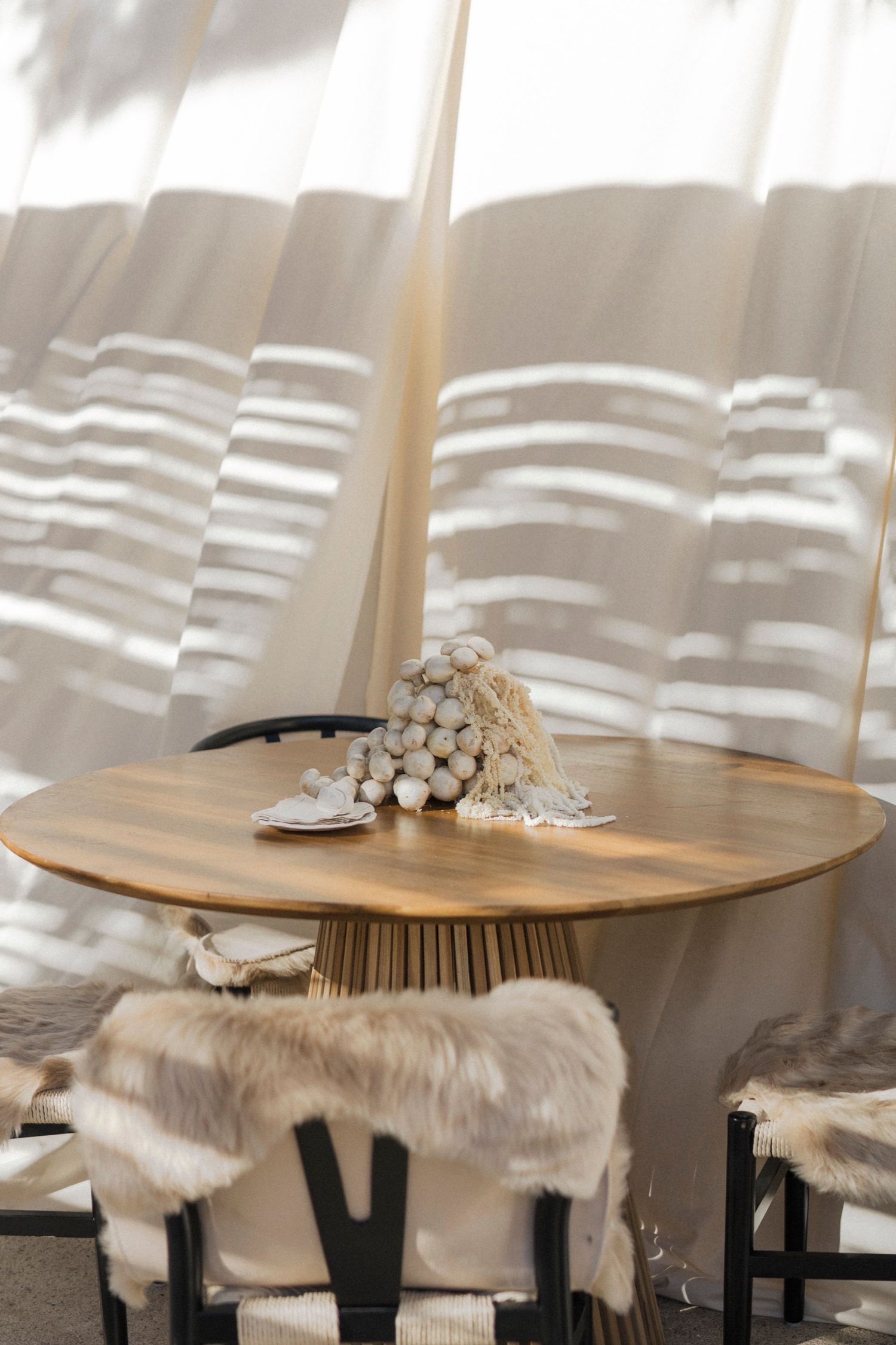 Elegant chairs with fur throws and floral decorations arranged at a wedding reception.