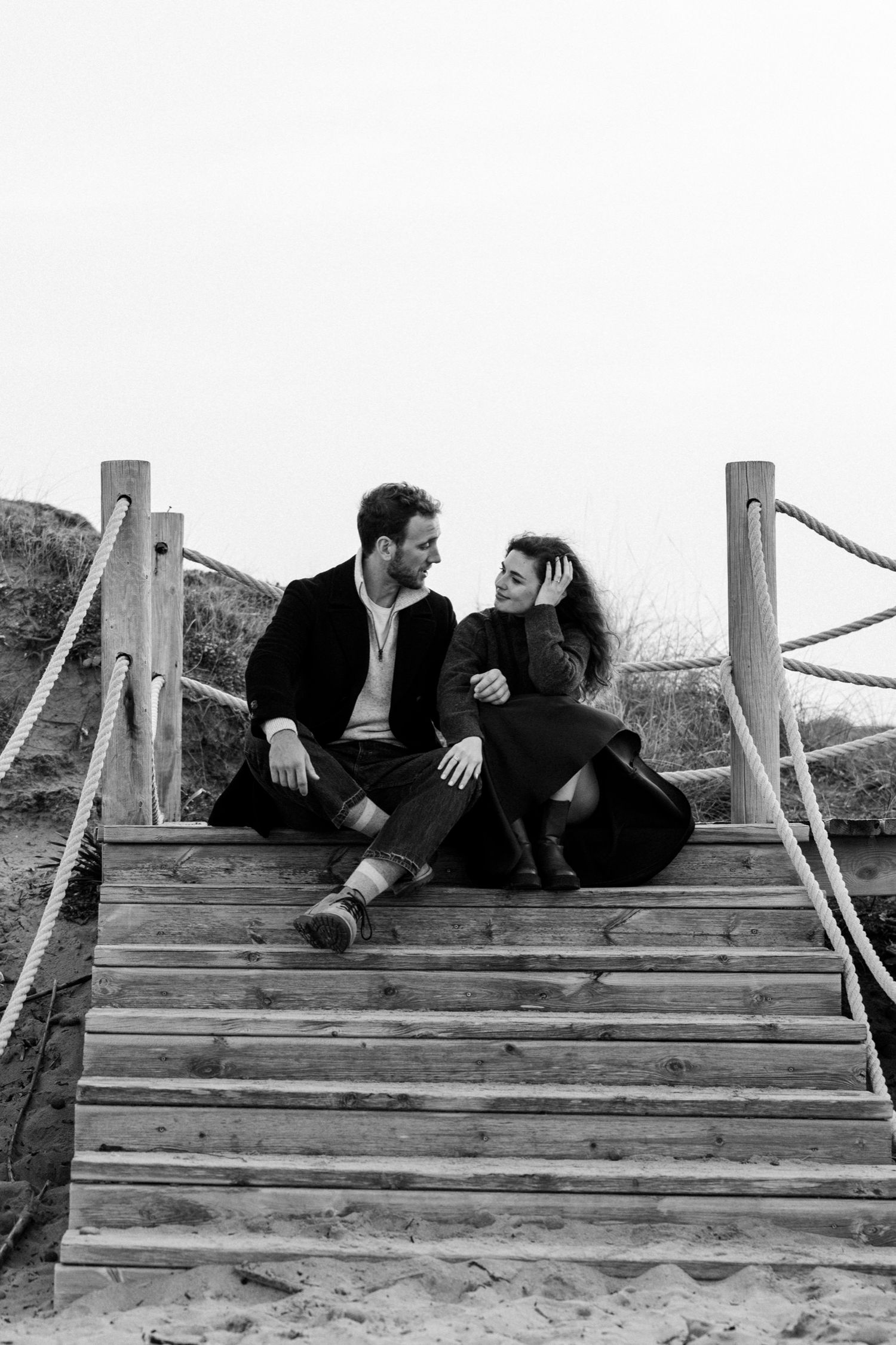 A sequence of romantic moments captured on wooden steps outdoors.