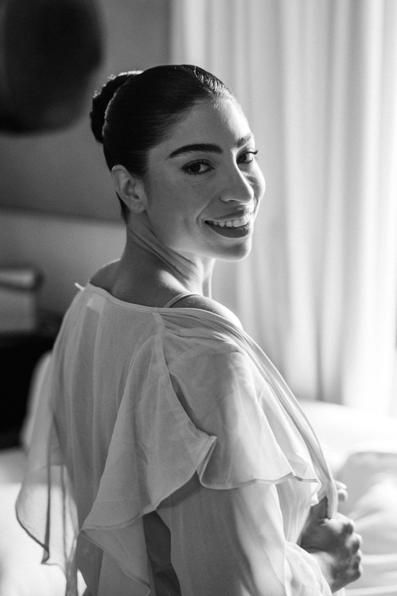 Black and white portraits showing elegant feminine poses with ruffled white clothing against a bright window.
