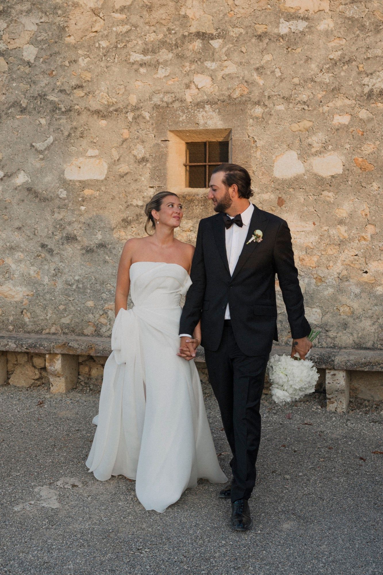 Wedding couple walks and poses along rustic stone wall in series of candid shots.
