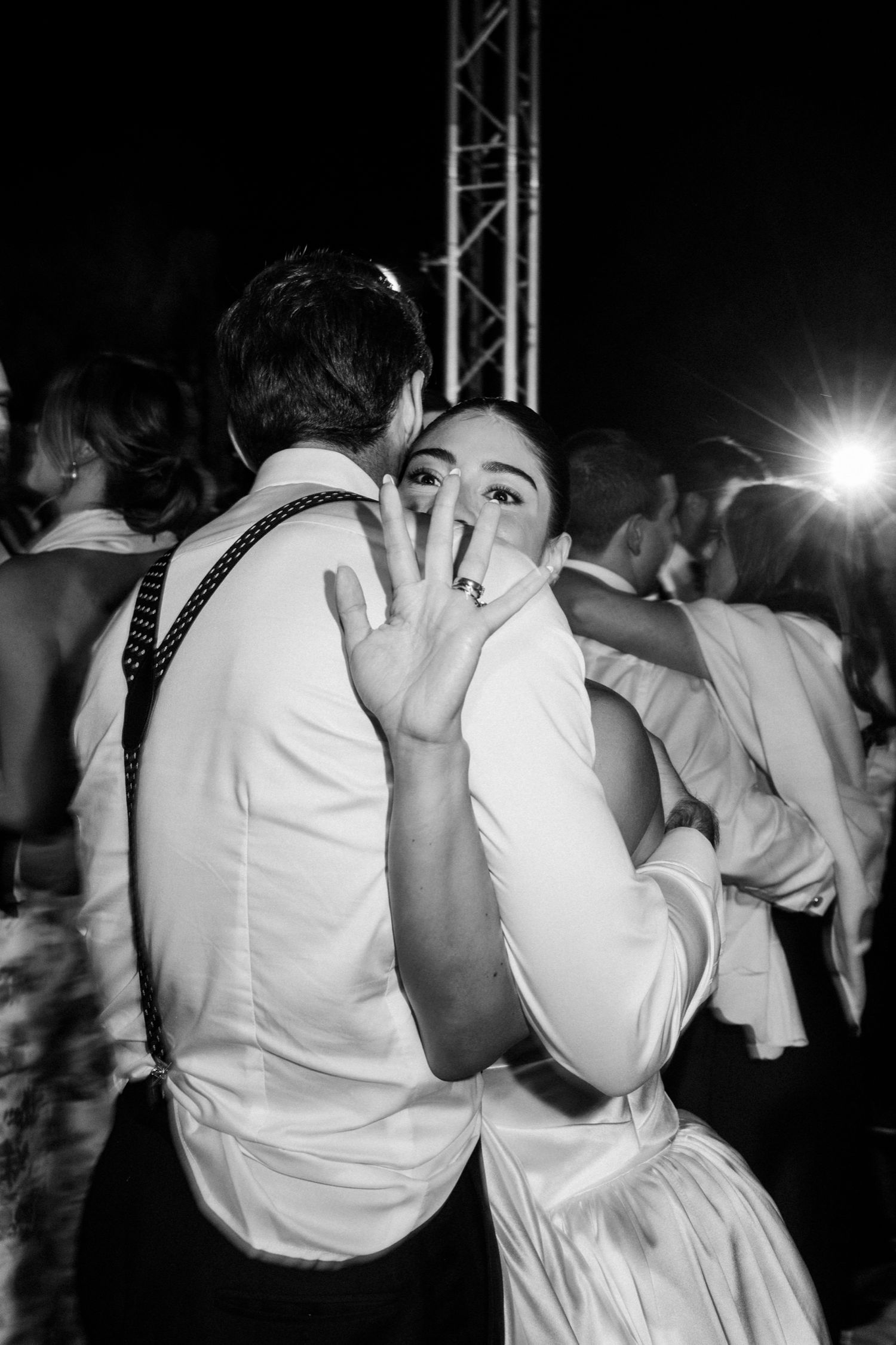 A sequence of black and white photos showing dancers in white outfits performing at a nighttime event.