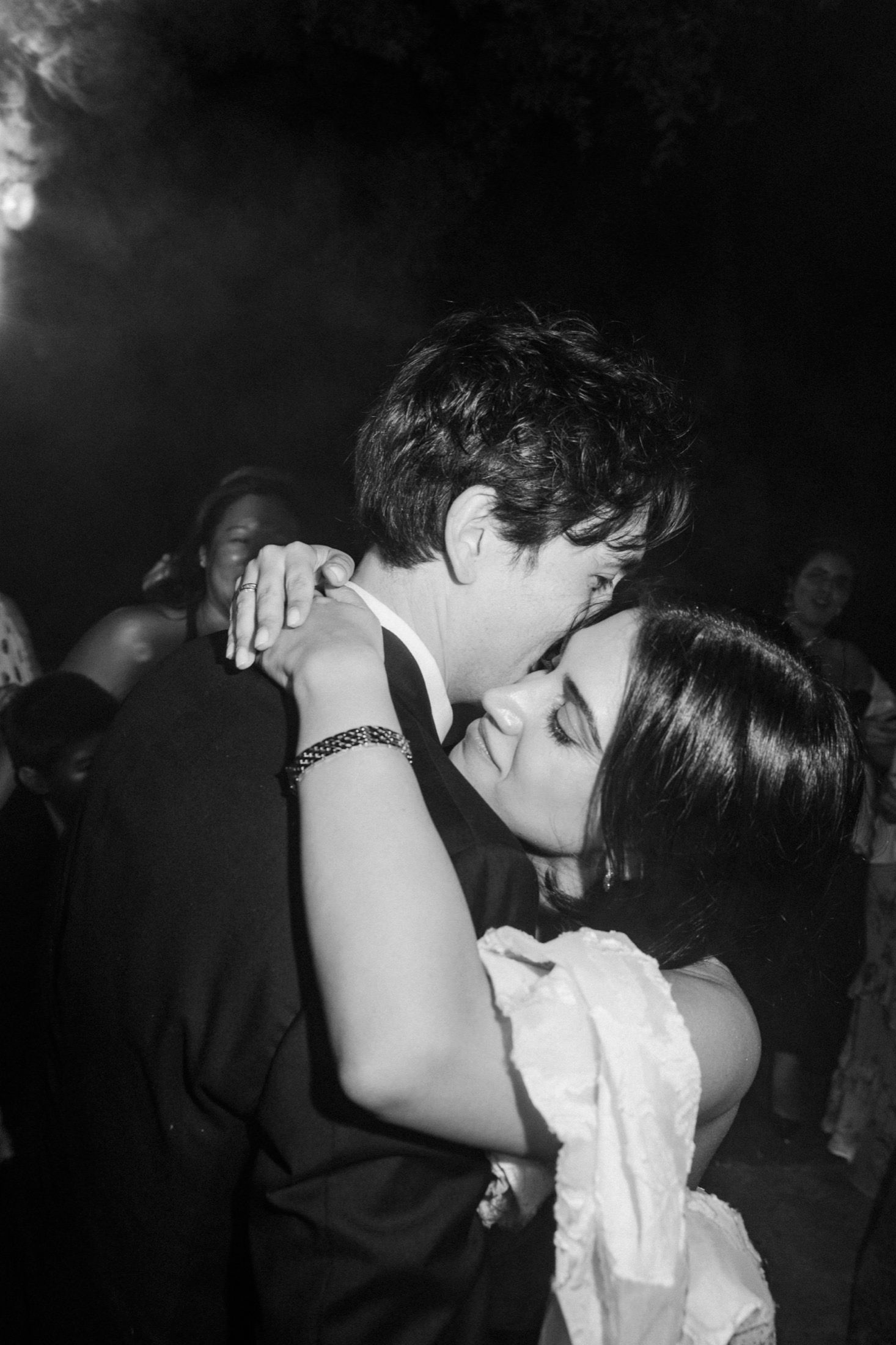 Black and white photo series showing couples embracing and dancing at a dimly lit party or nightclub.