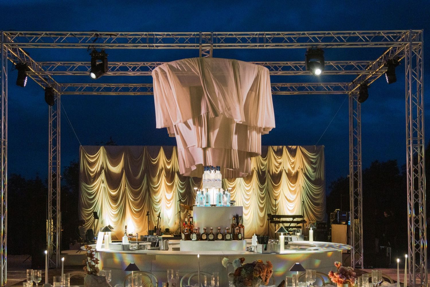 Stage lighting illuminates an ornate theater interior with golden drapes and architectural details during a performance.
