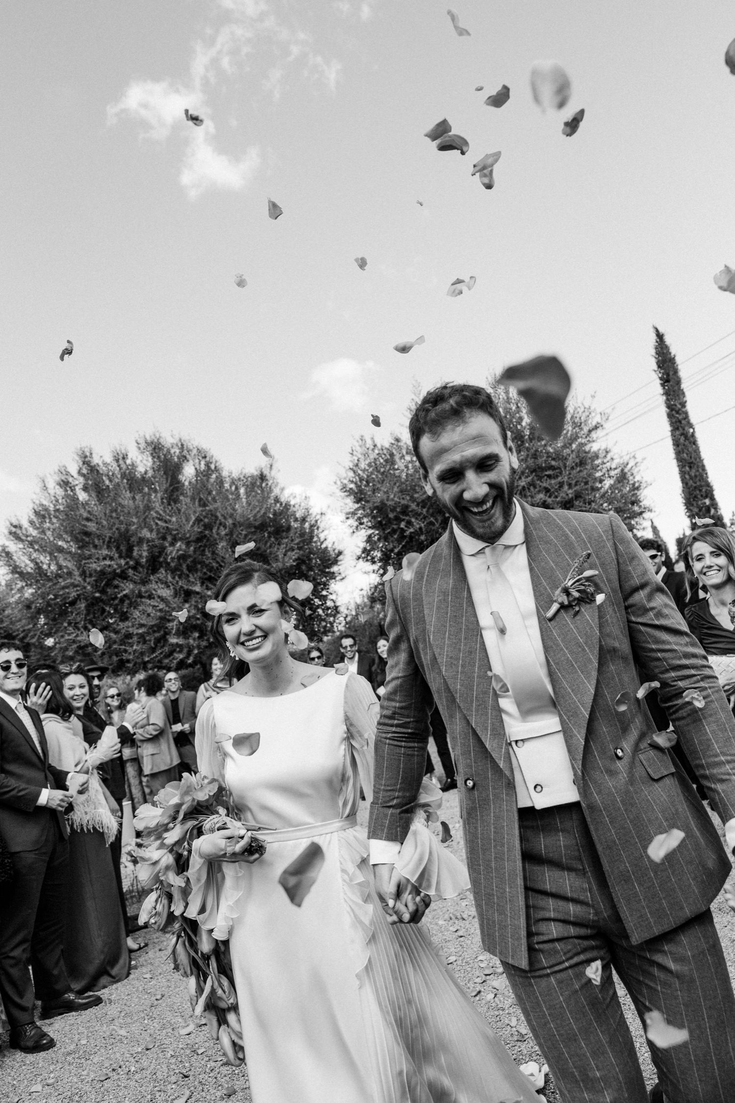Black and white wedding sequence showing newlyweds celebrating with guests throwing confetti in an outdoor garden setting.