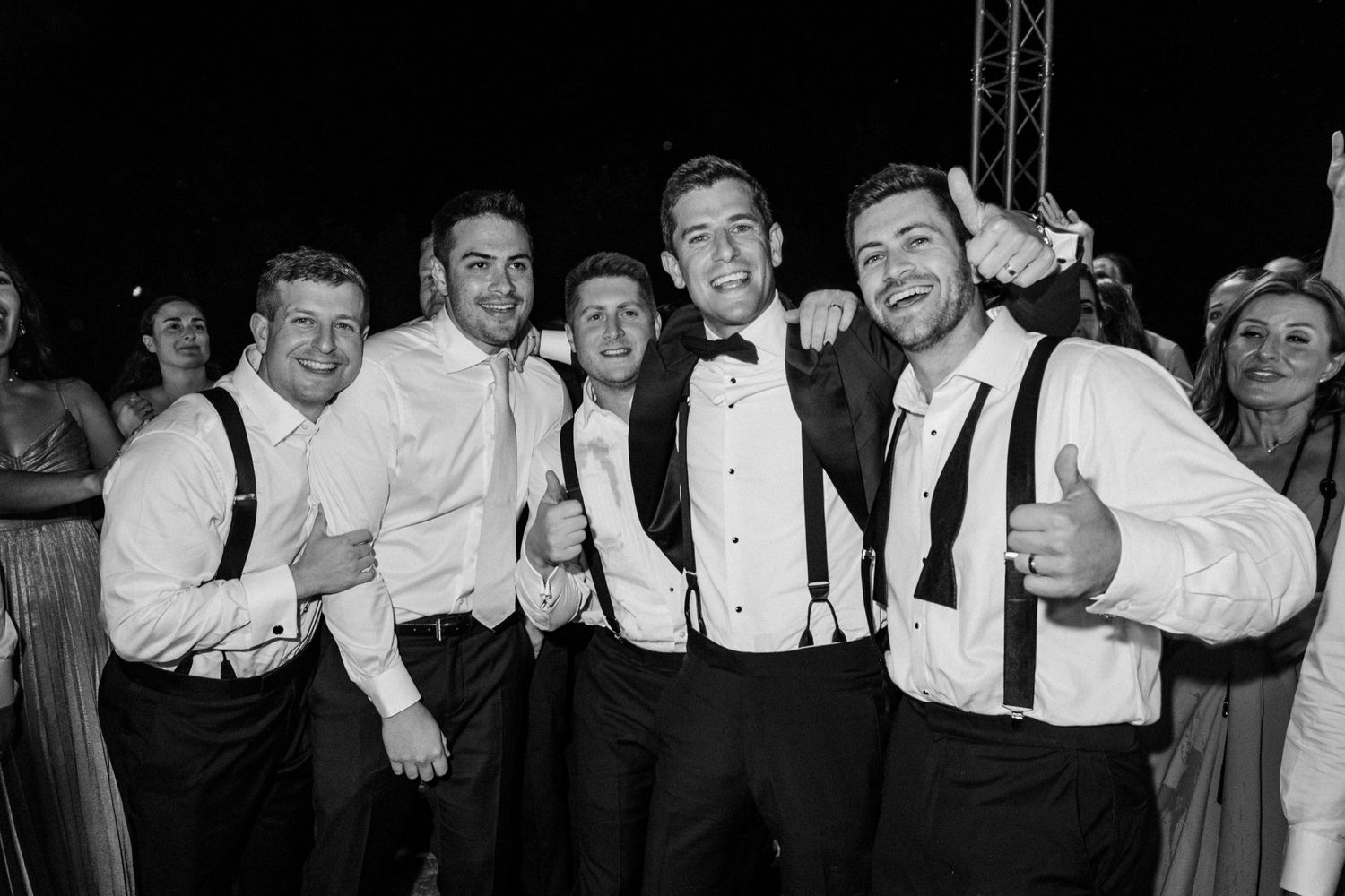 A group of people in formal attire pose together in a black and white photograph.