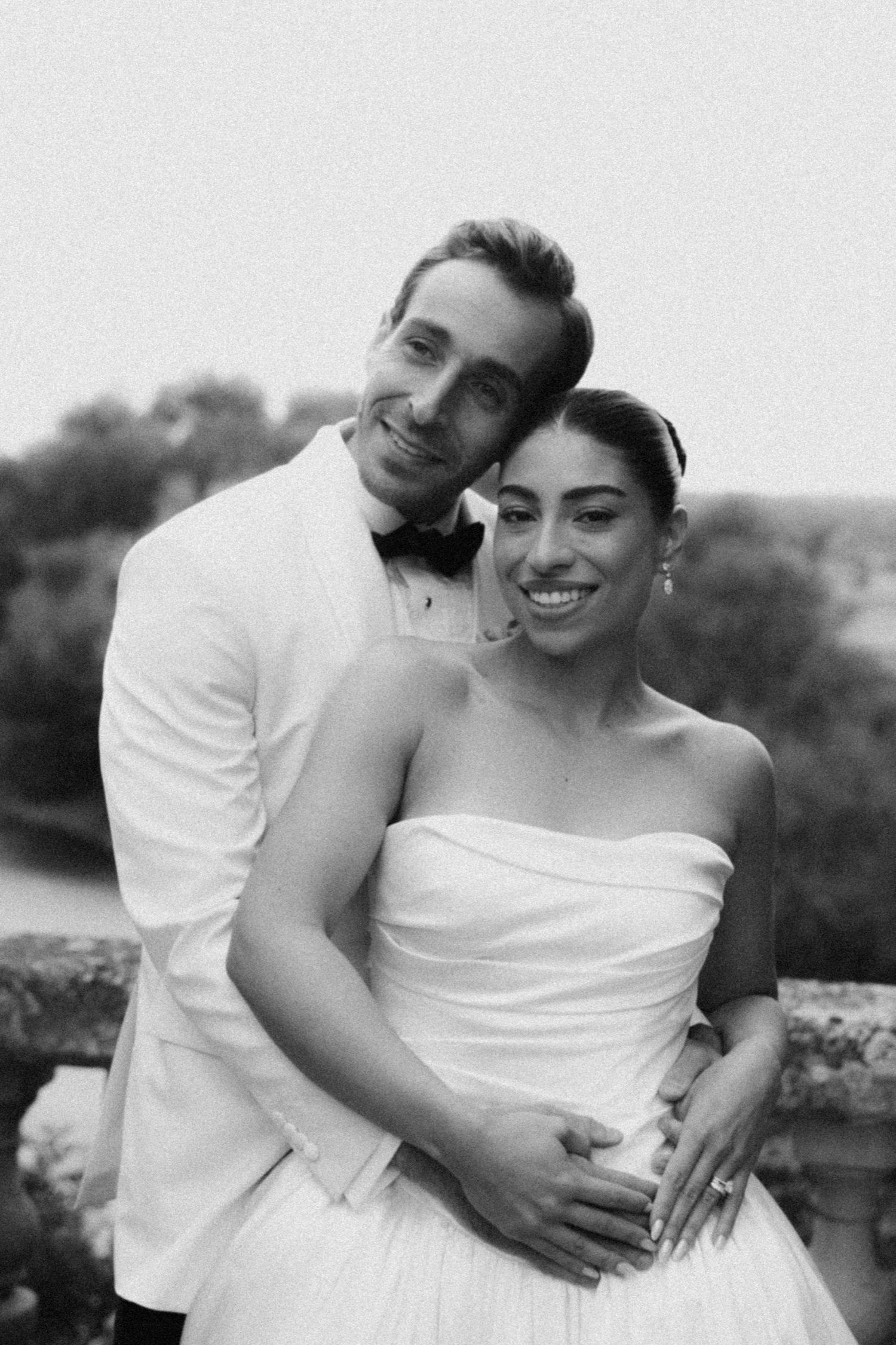 A black and white photo series shows a romantic couple embracing in wedding attire outdoors.