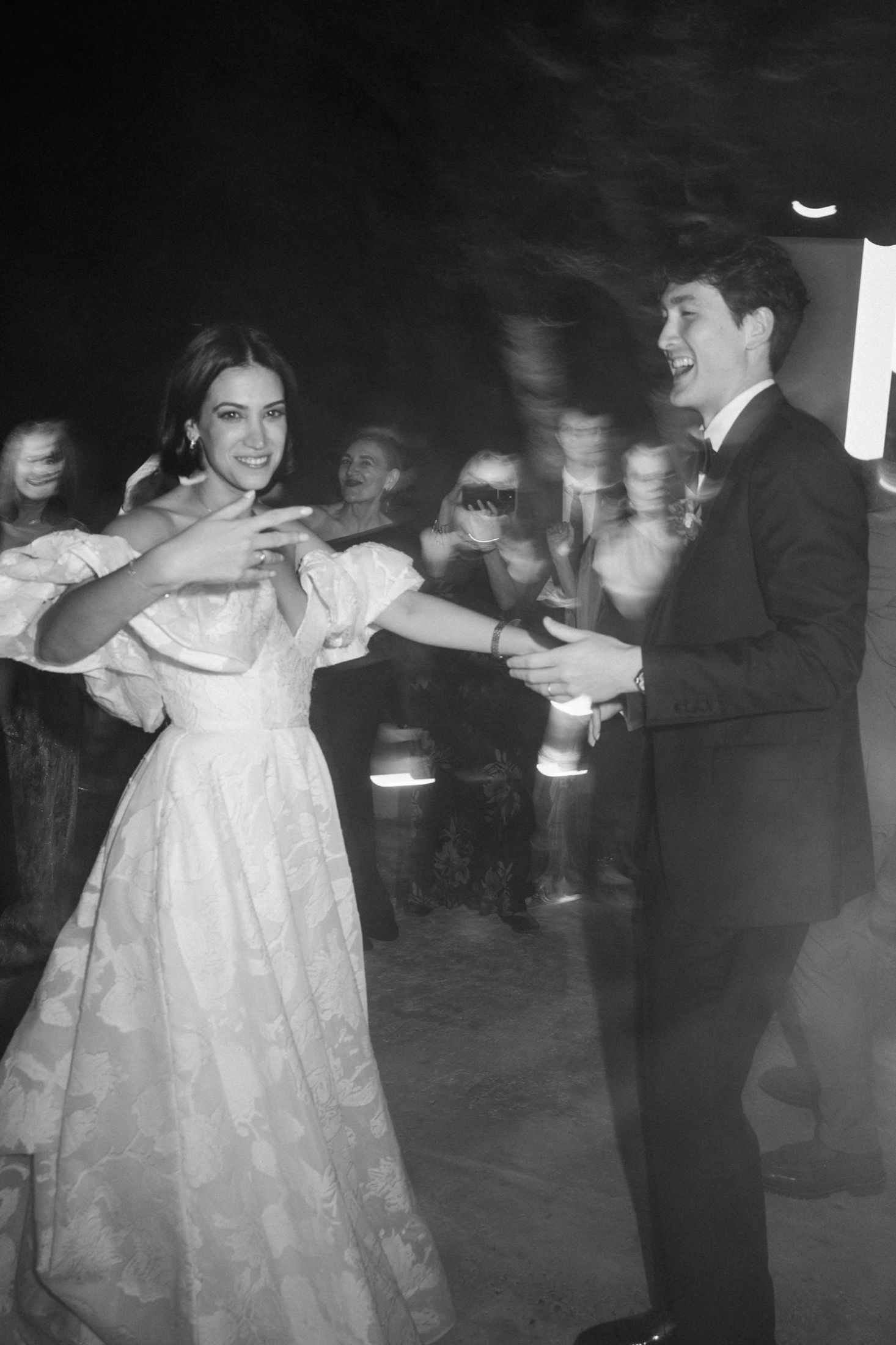 A black and white photo series shows a couple dancing together at a formal event in vintage attire.