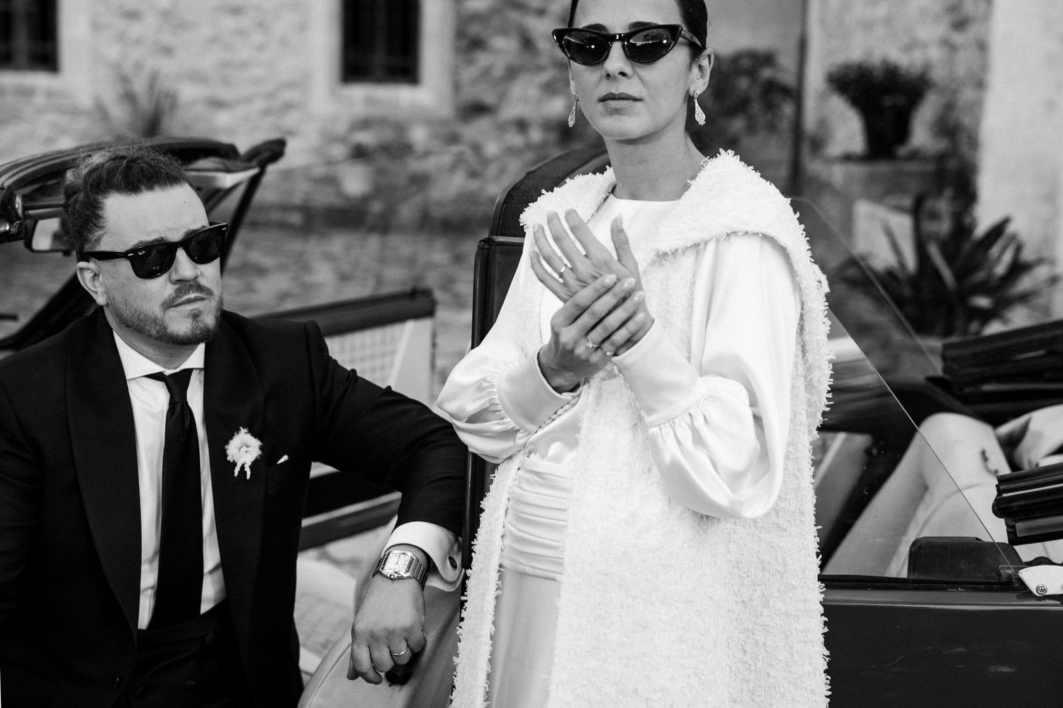Stylish couple in sunglasses and formal wear posing in black and white photography.