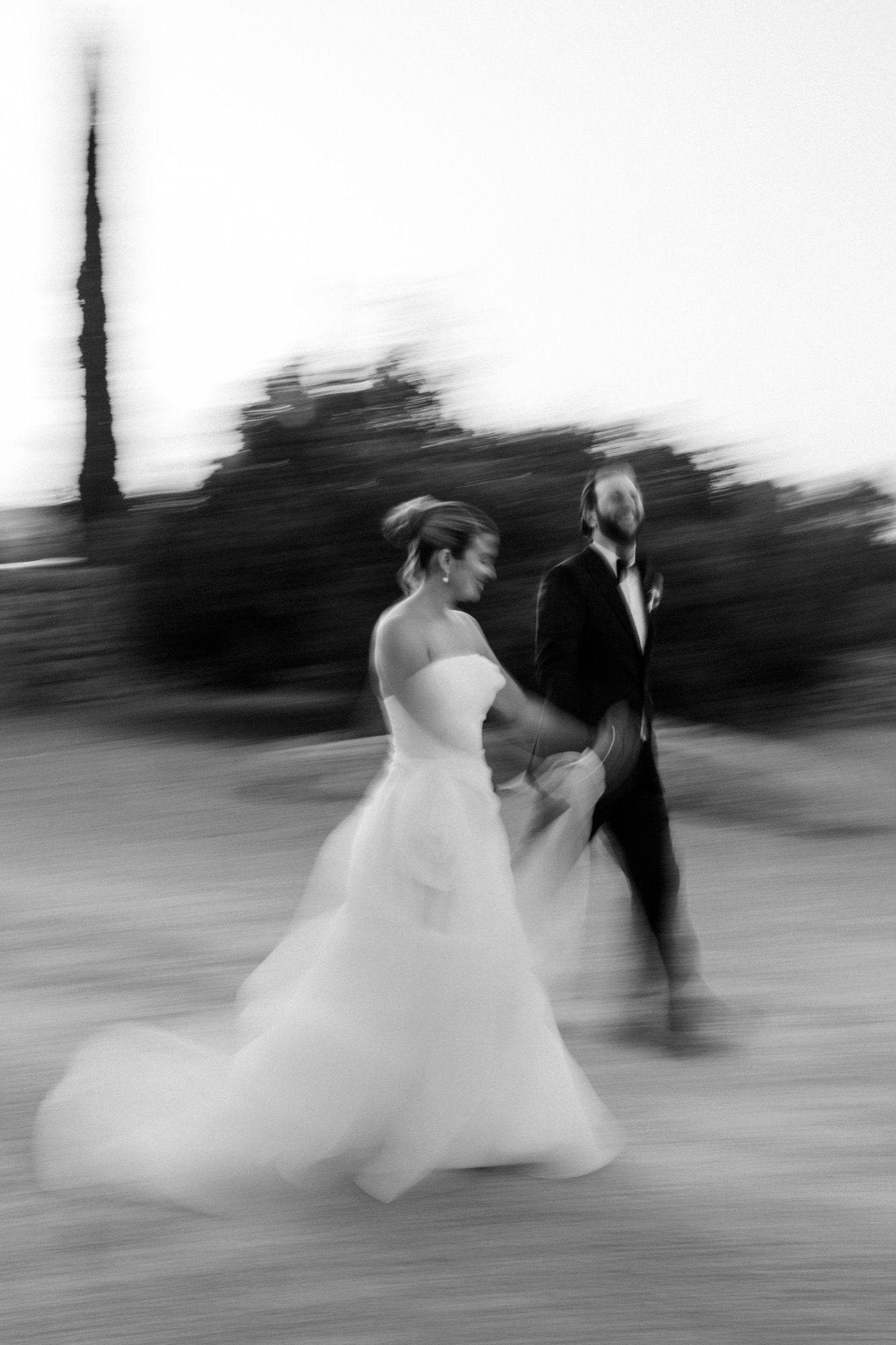 Abstract black and white motion shots capture newlyweds dancing outdoors.