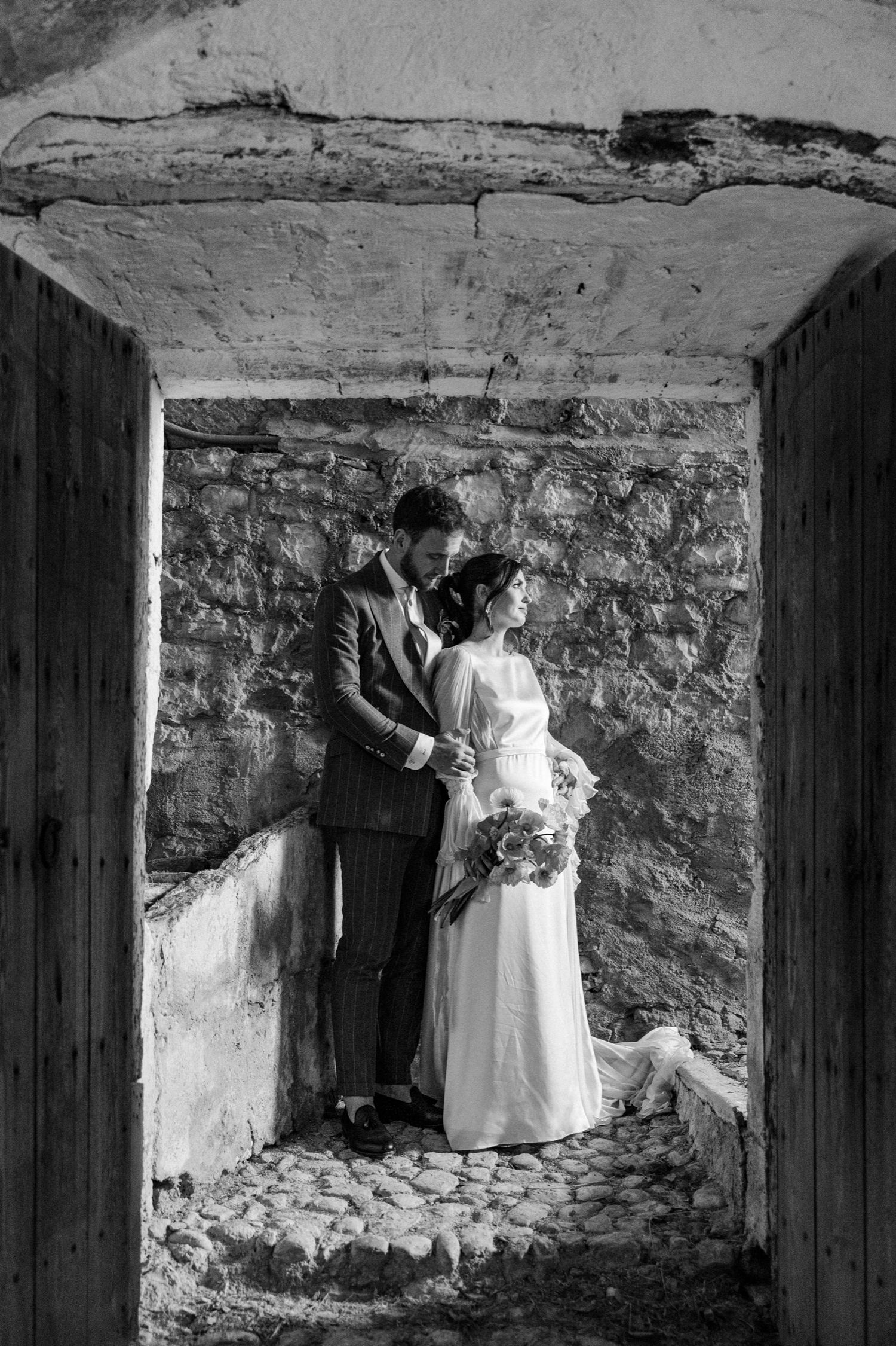 A sequence of black and white photographs showing figures in white dresses exploring a dimly lit stone cellar.