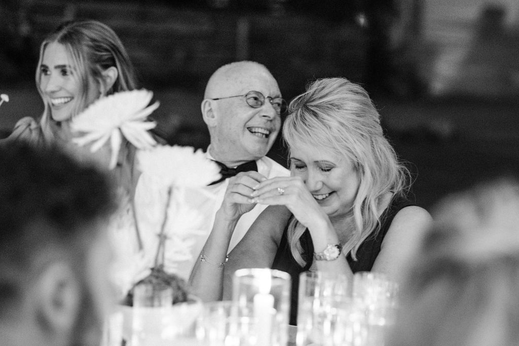 Black and white photo of wedding guests enjoying emotional reception moments.