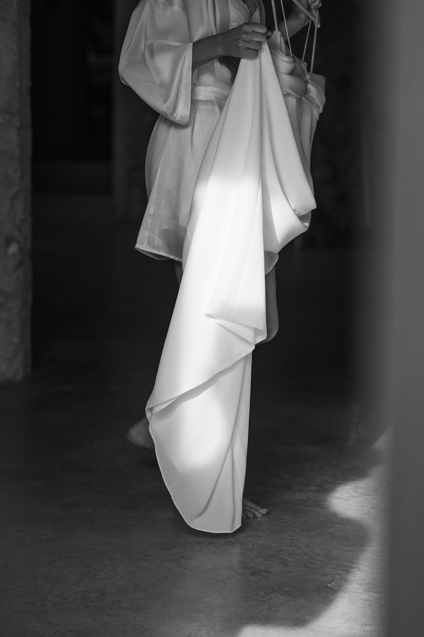 A ghostly figure in flowing white robes stands in a dimly lit hallway creating an ethereal atmosphere.