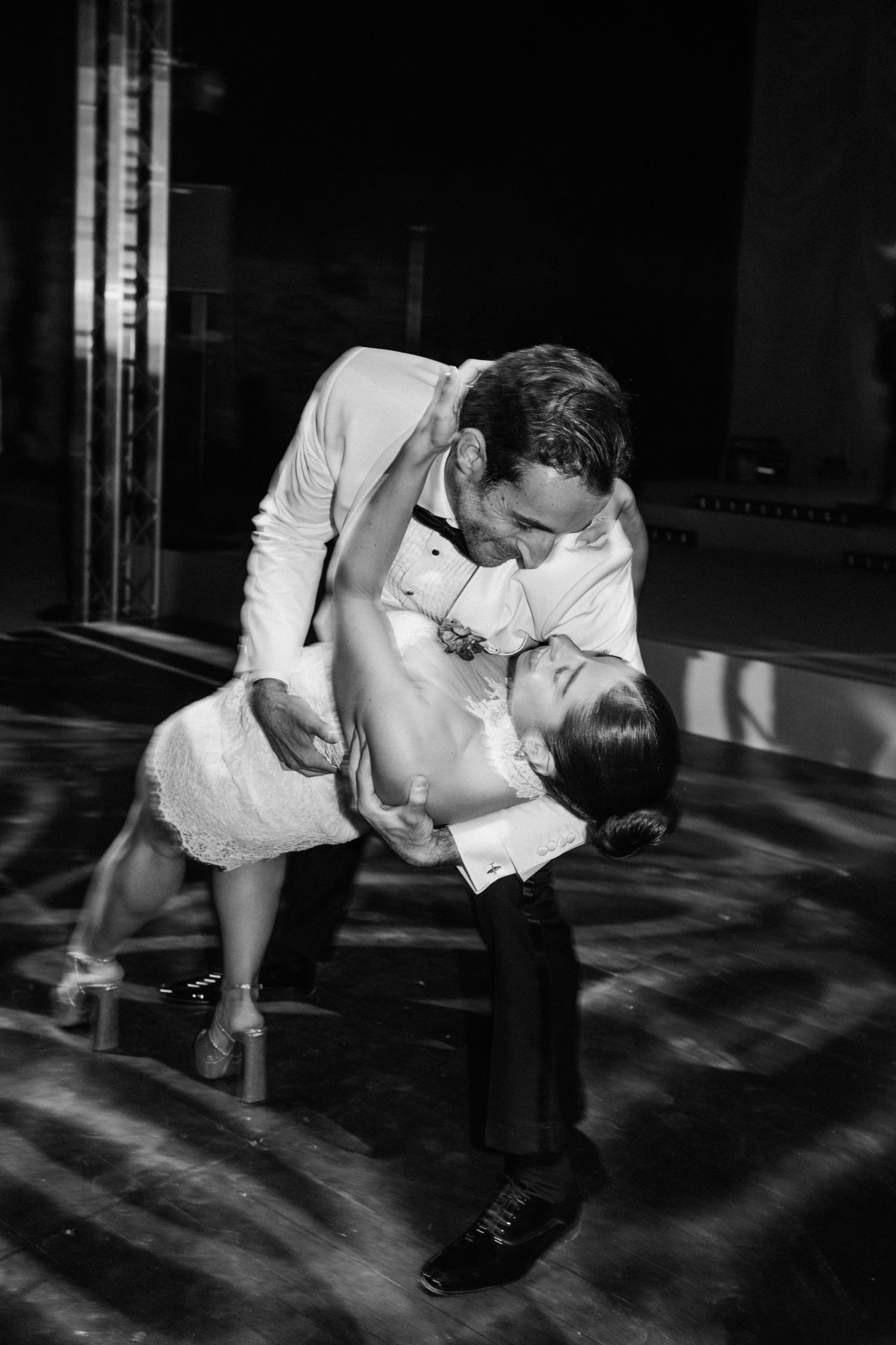 A black and white sequence shows a dancer performing a dynamic sideways leap across a shadowy floor.