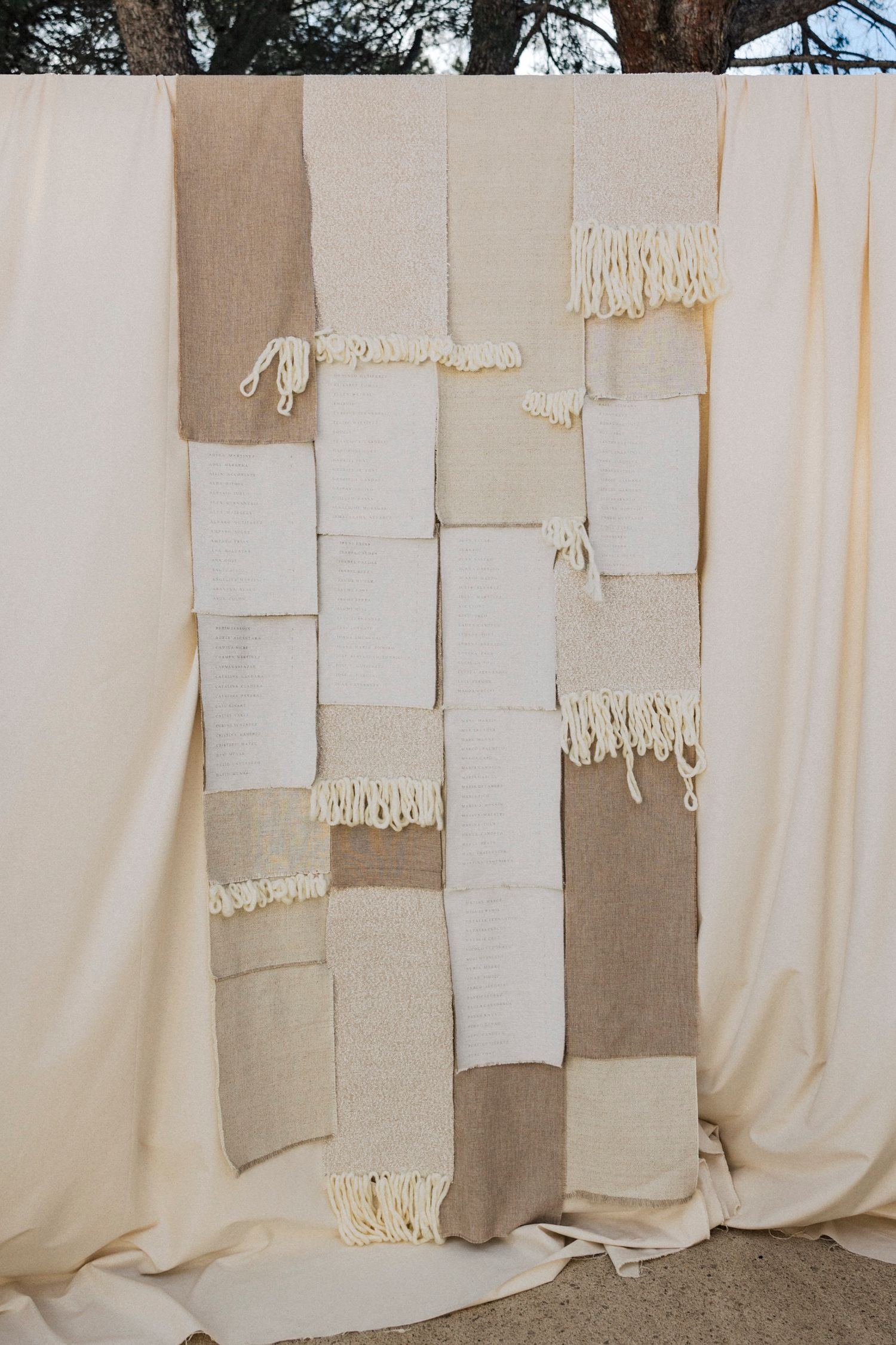 Textured neutral fabric panels create an artistic wedding backdrop display.