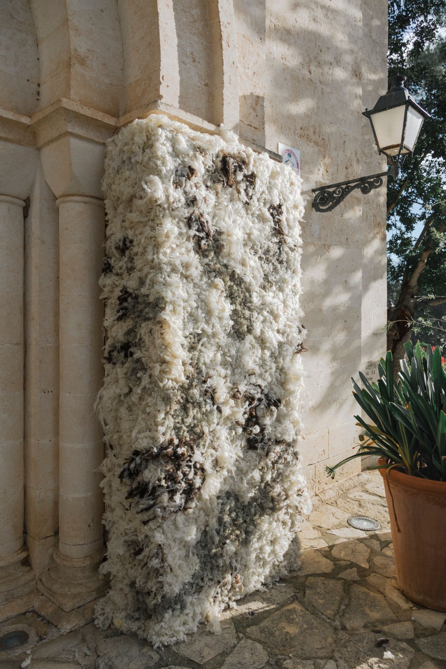 Textured white installation against stone church exterior wall.
