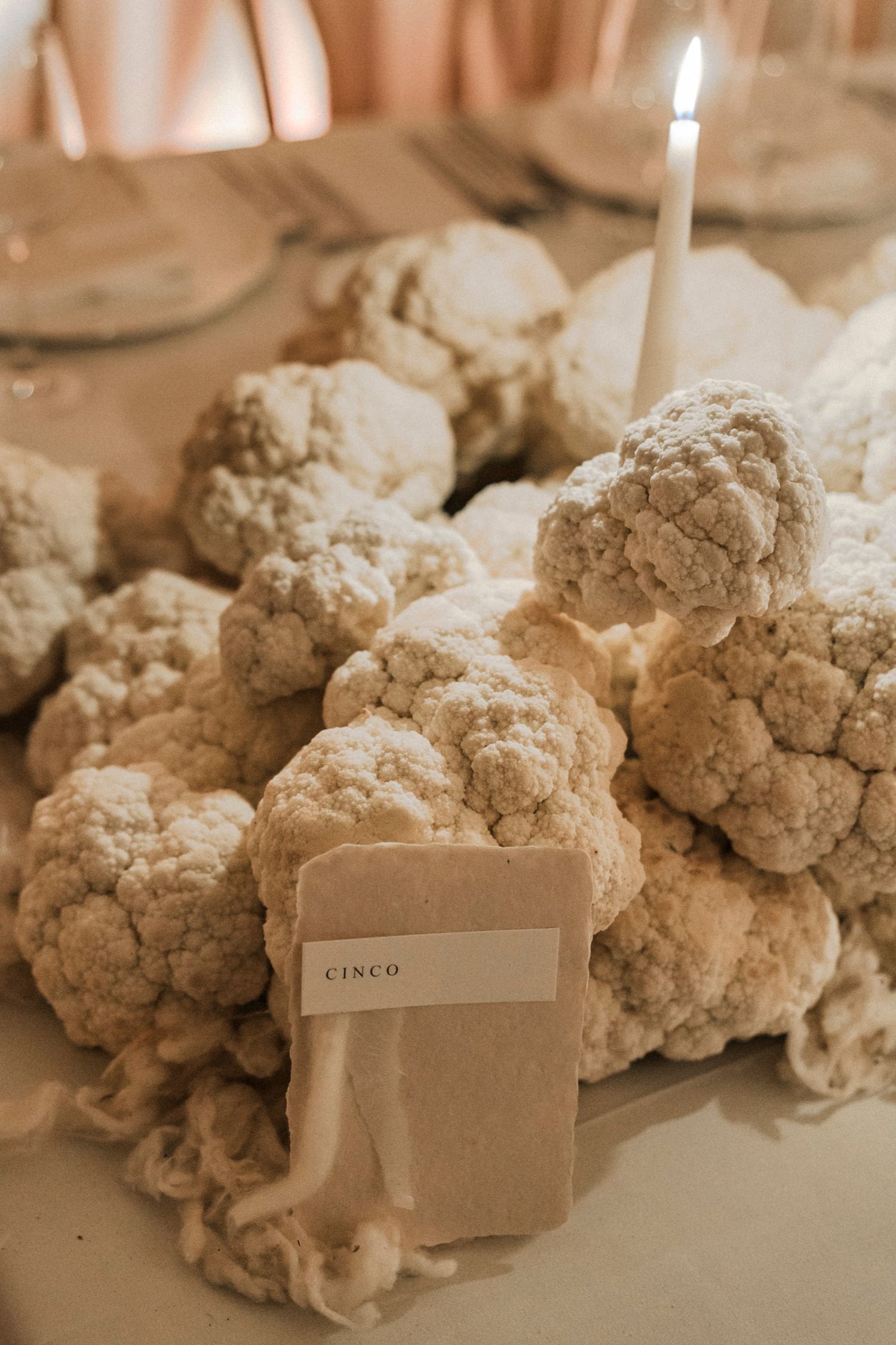 White cotton-like floral arrangements with place cards set on elegant dining table.