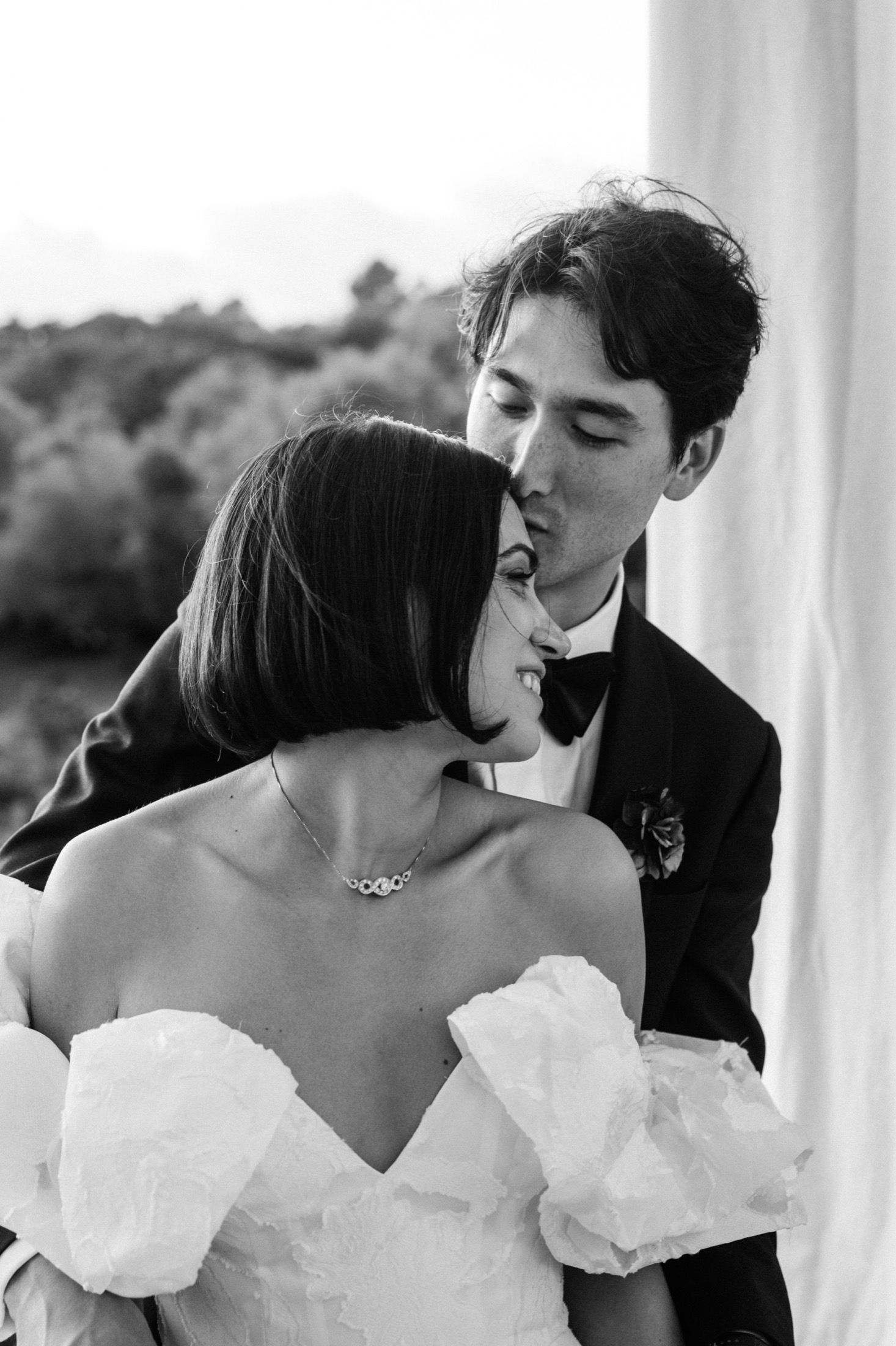 Black and white sequence of romantic wedding couple kissing in elegant formal attire.