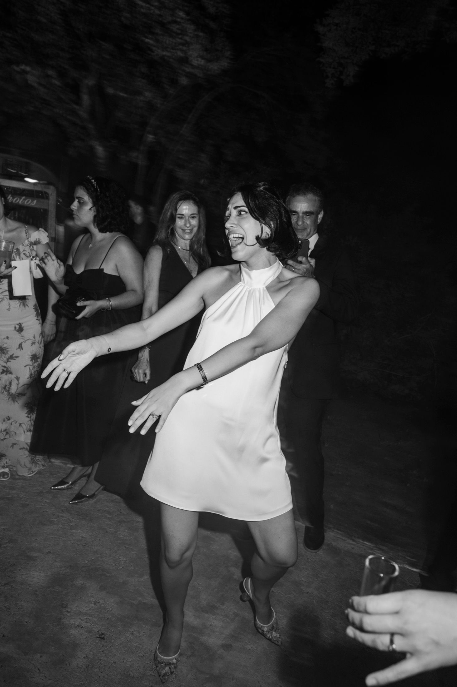 Black and white photo sequence shows dancers in motion performing energetic swing dance moves on a dark dance floor.
