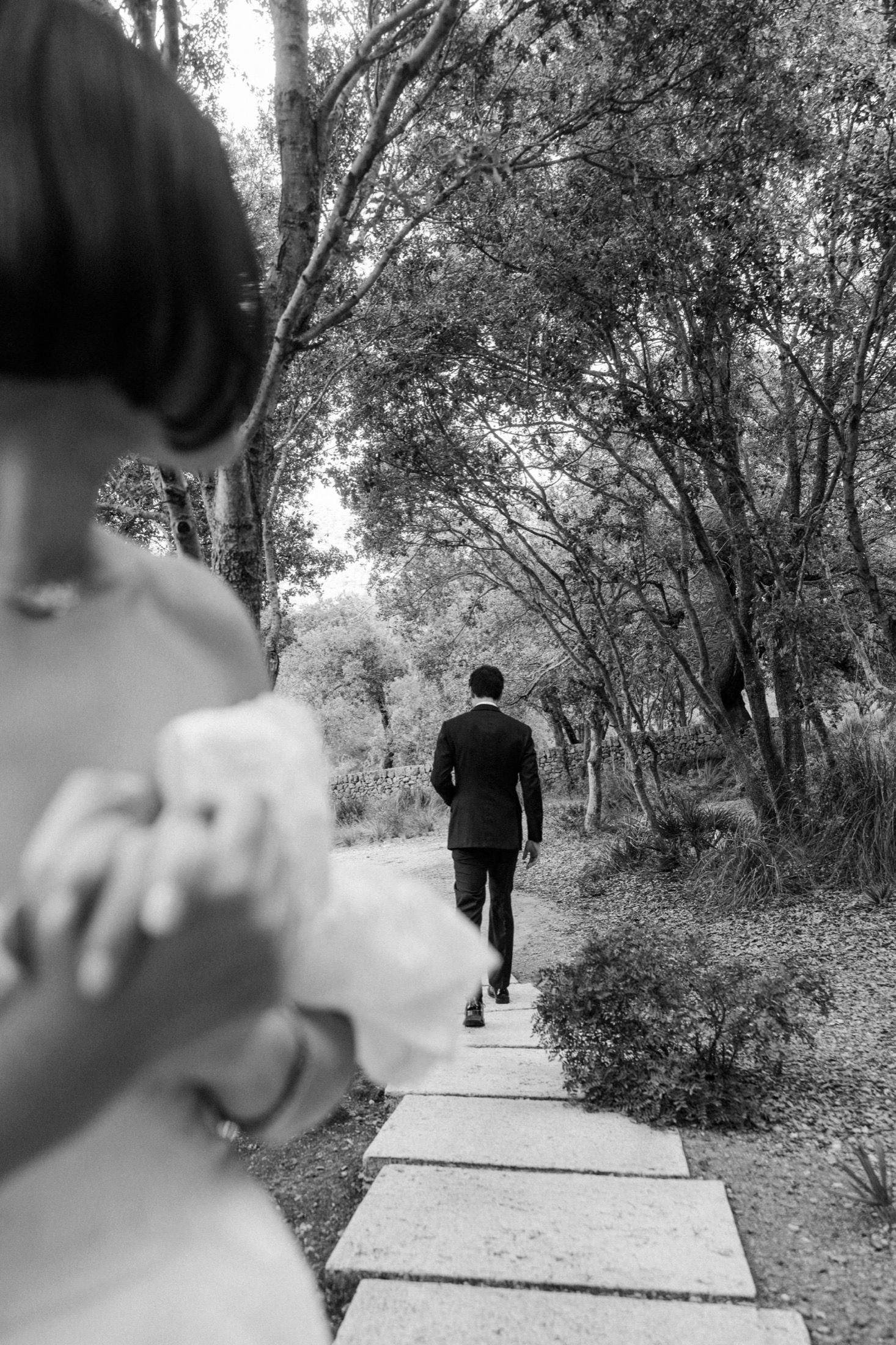 Black and white photo series showing someone walking along a tree-lined path from behind in a natural setting.