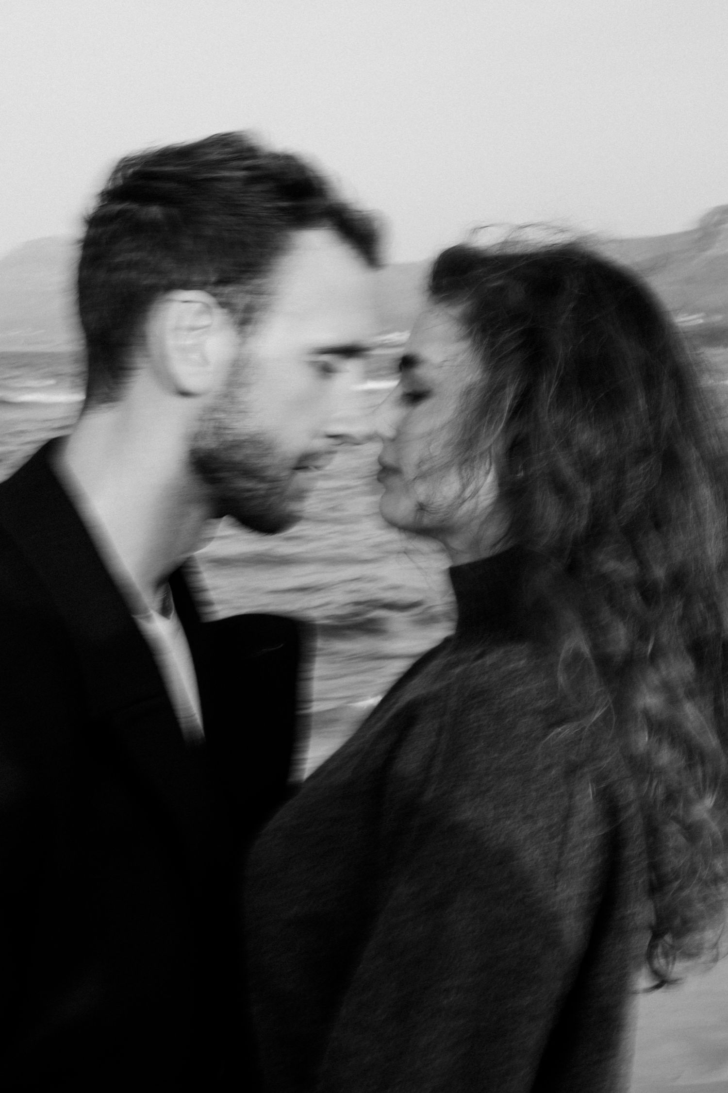 A series of black and white romantic photos showing a couple in an intimate moment on a blurry background.