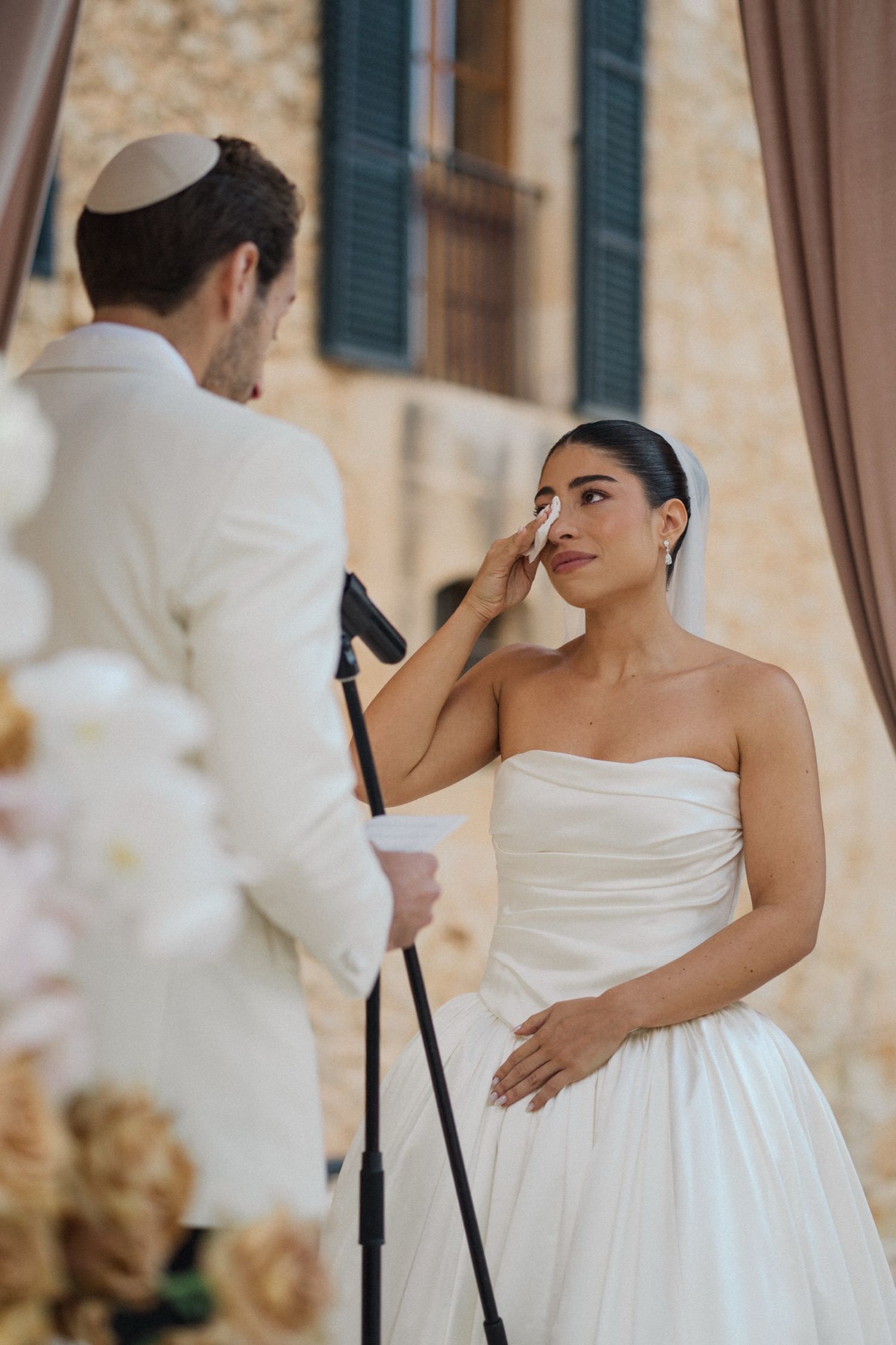 A series of romantic wedding photos showing tender moments between a couple in white attire at an elegant venue.