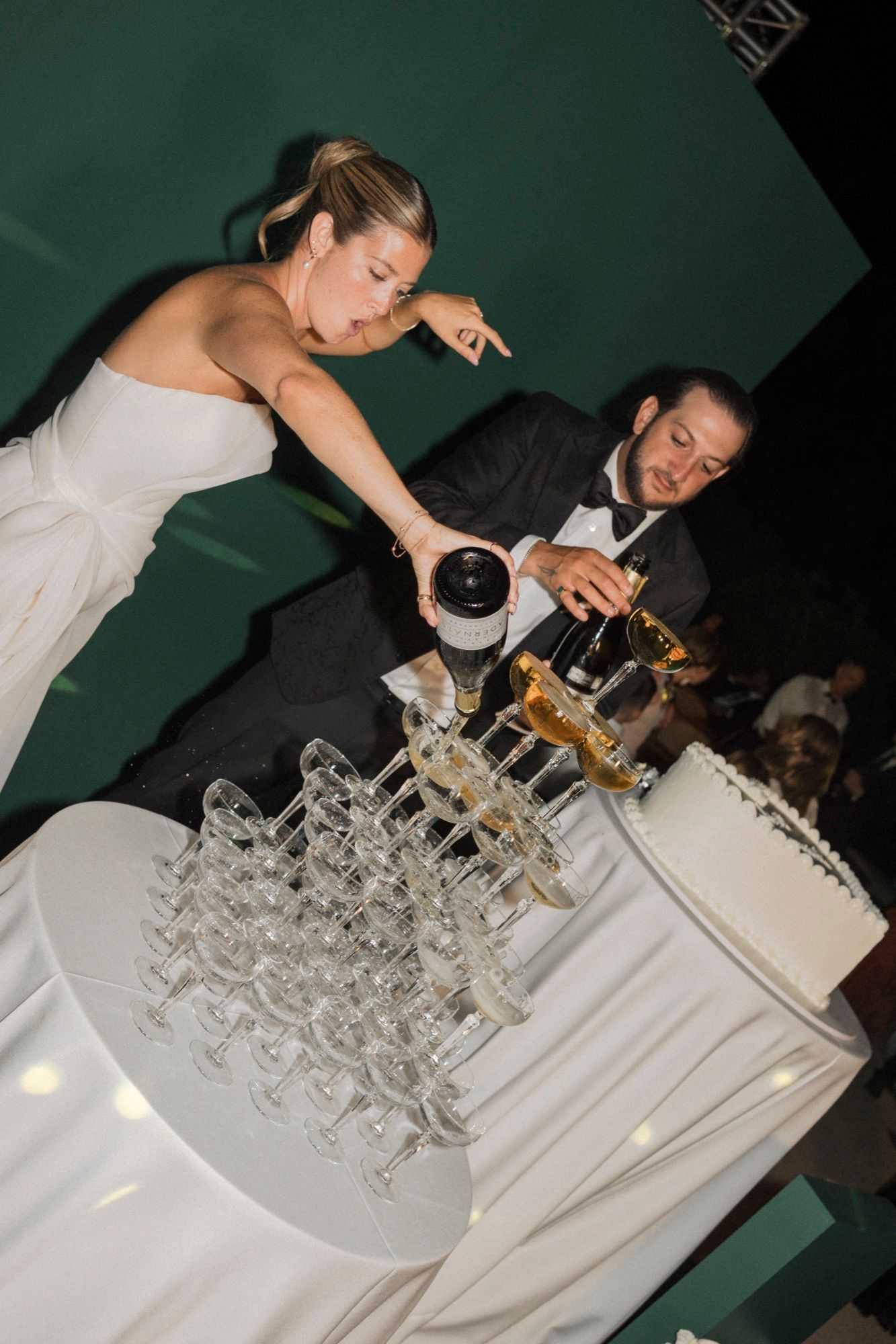 Wedding reception setup with champagne glasses arranged on white tablecloths.