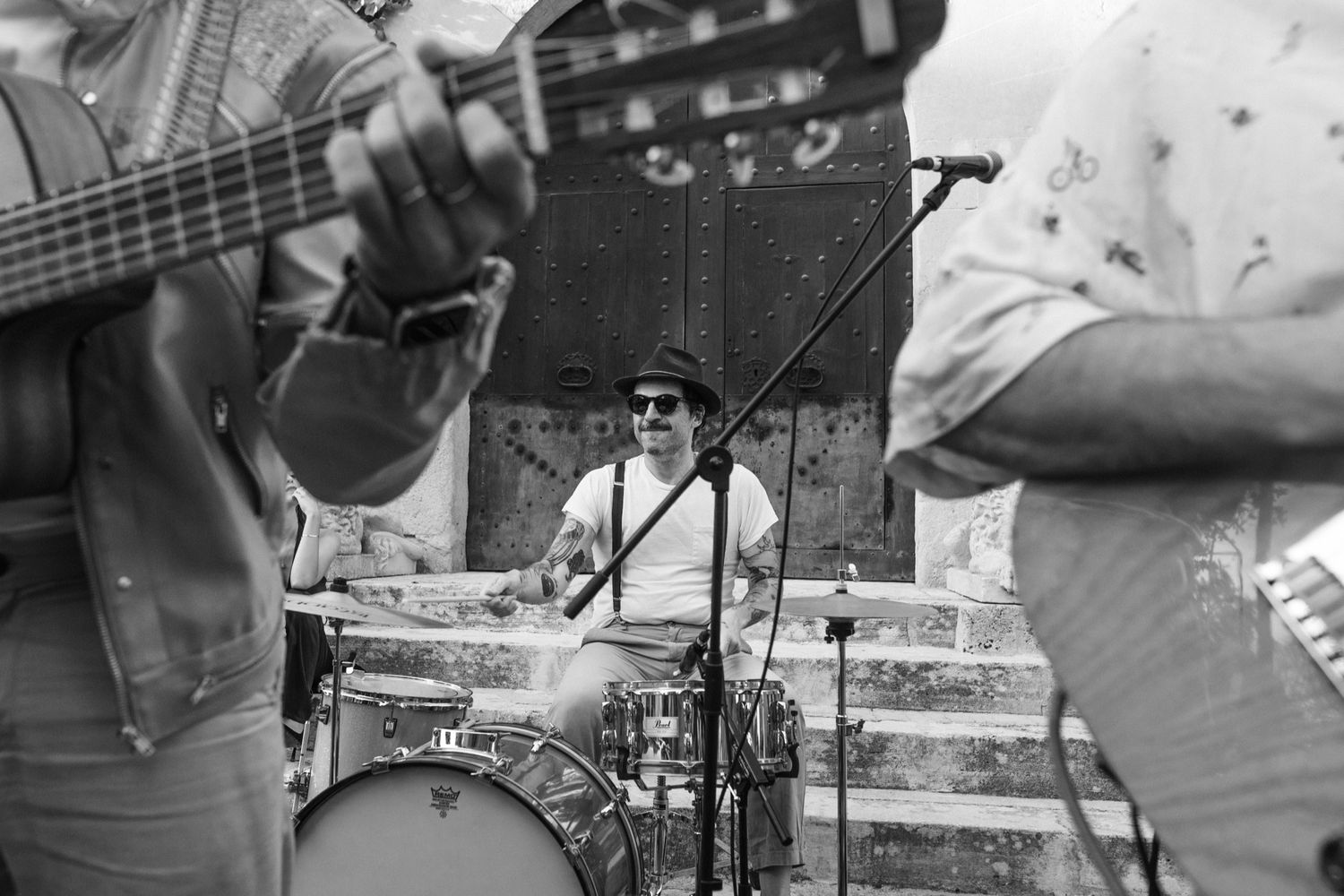 Musicians perform on stage at an outdoor concert with guitars and other instruments.