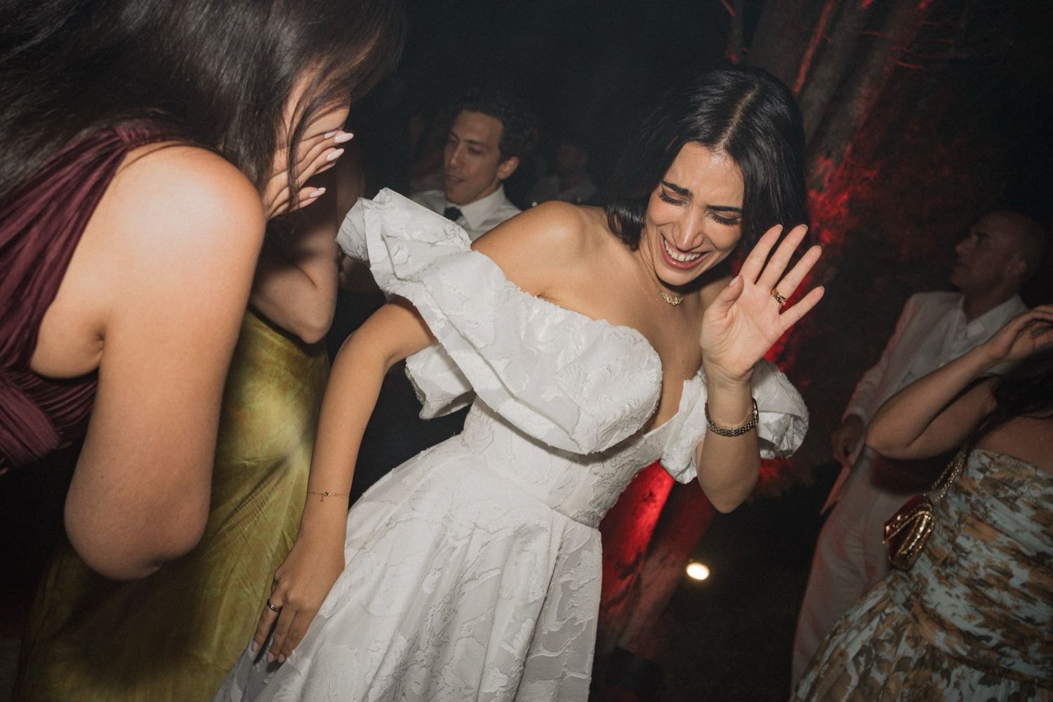 Guests enjoying themselves on a dimly lit dance floor at a party.