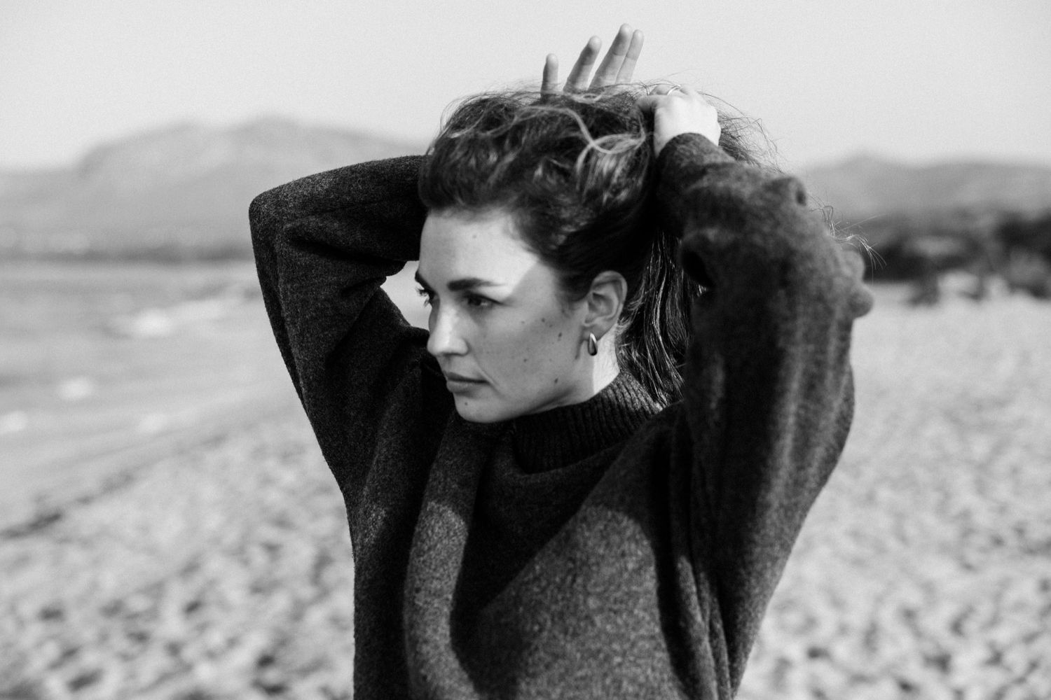 A black and white photo series showing someone in dramatic poses against a natural outdoor background.