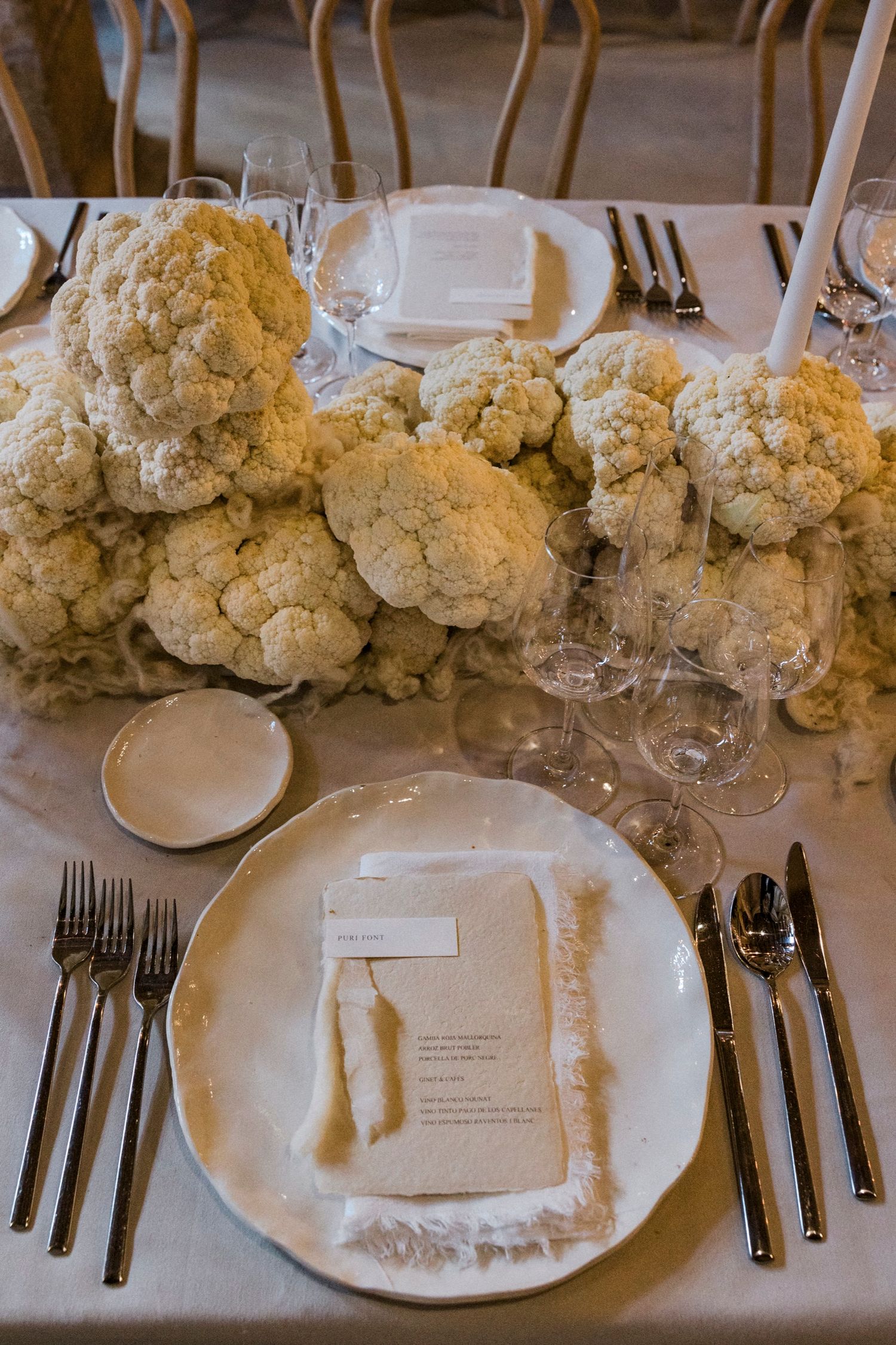 Elegant wedding table setting with white floral centerpieces and formal place settings.